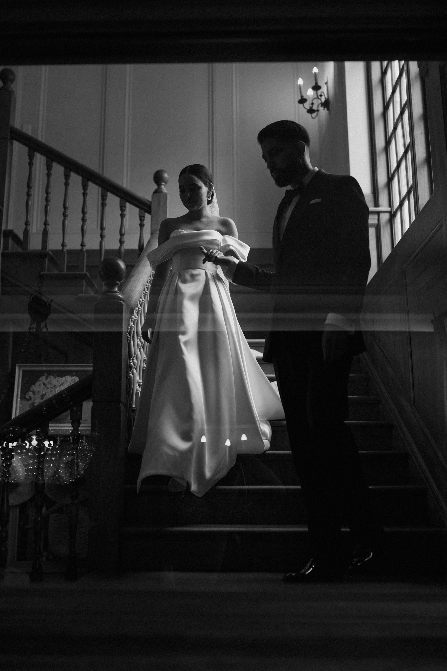 A dramatic black and white wedding photo on an elegant staircase.