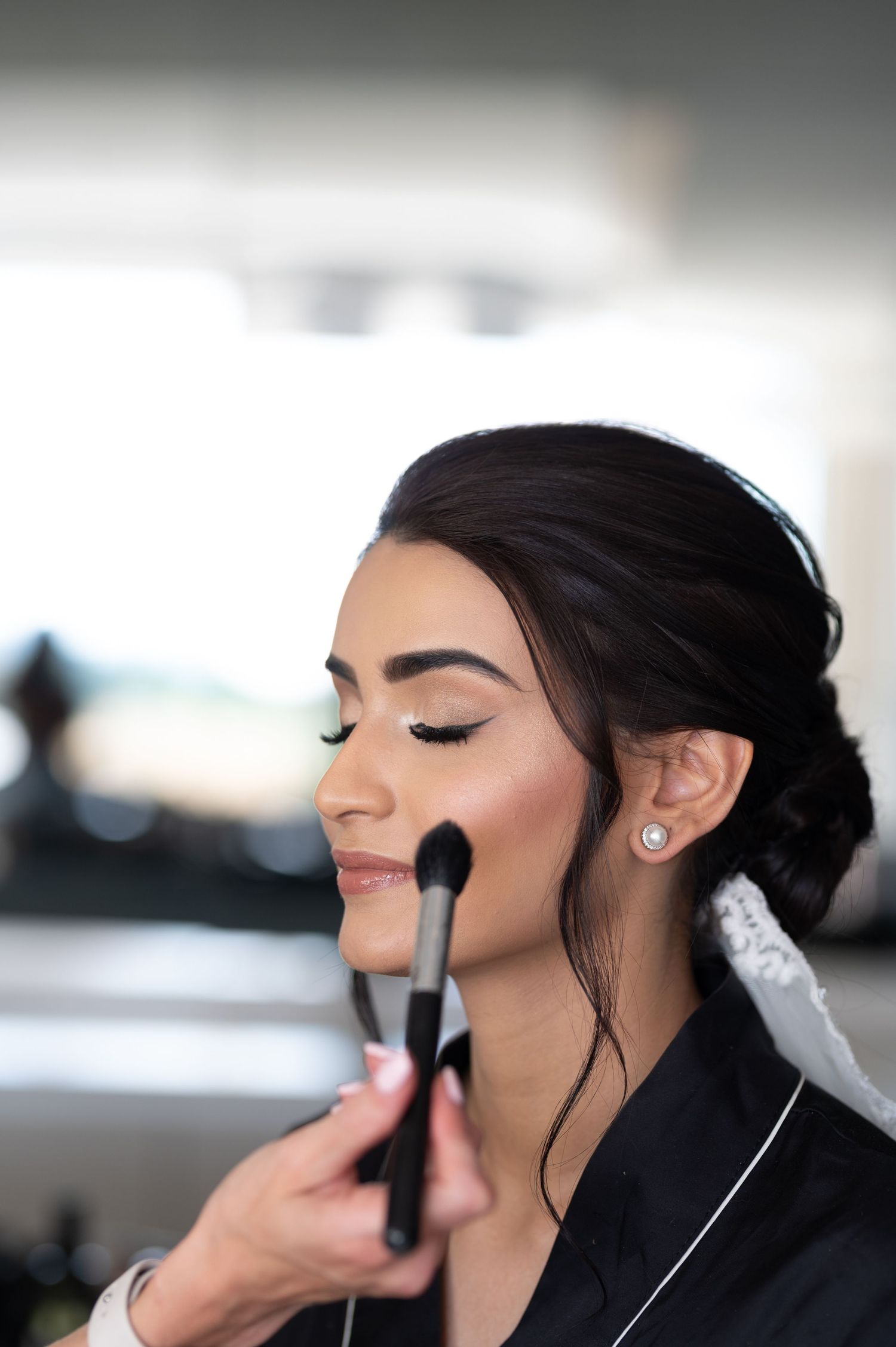 Wedding makeup application showing professional artistry and bridal beauty preparation.