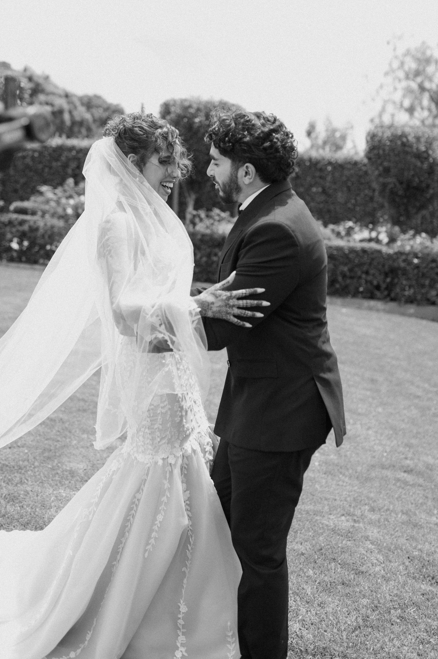 Black and white photo of newlyweds sharing an intimate moment on their wedding day.