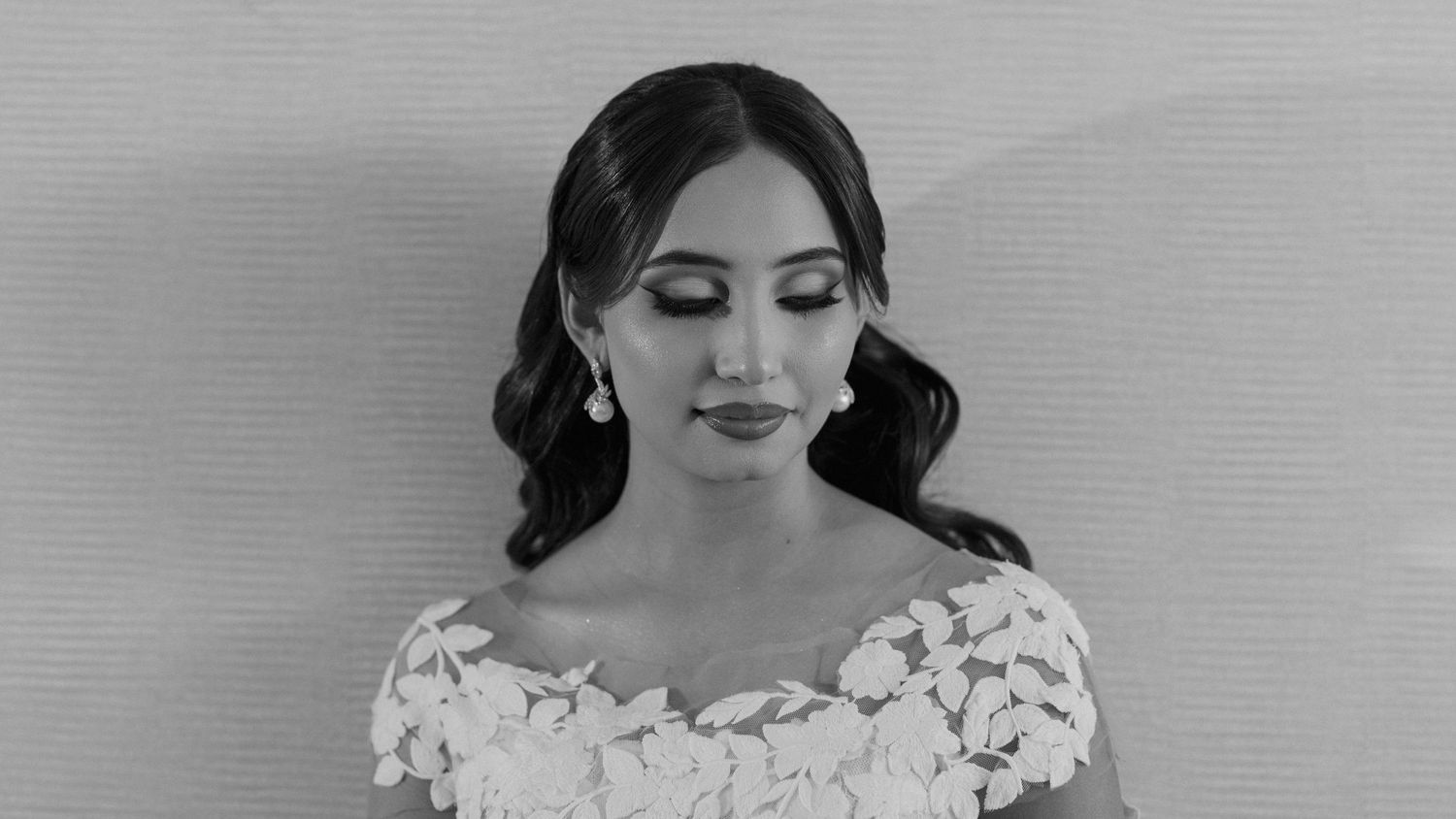 Black and white portrait of a bride in a lace wedding gown.