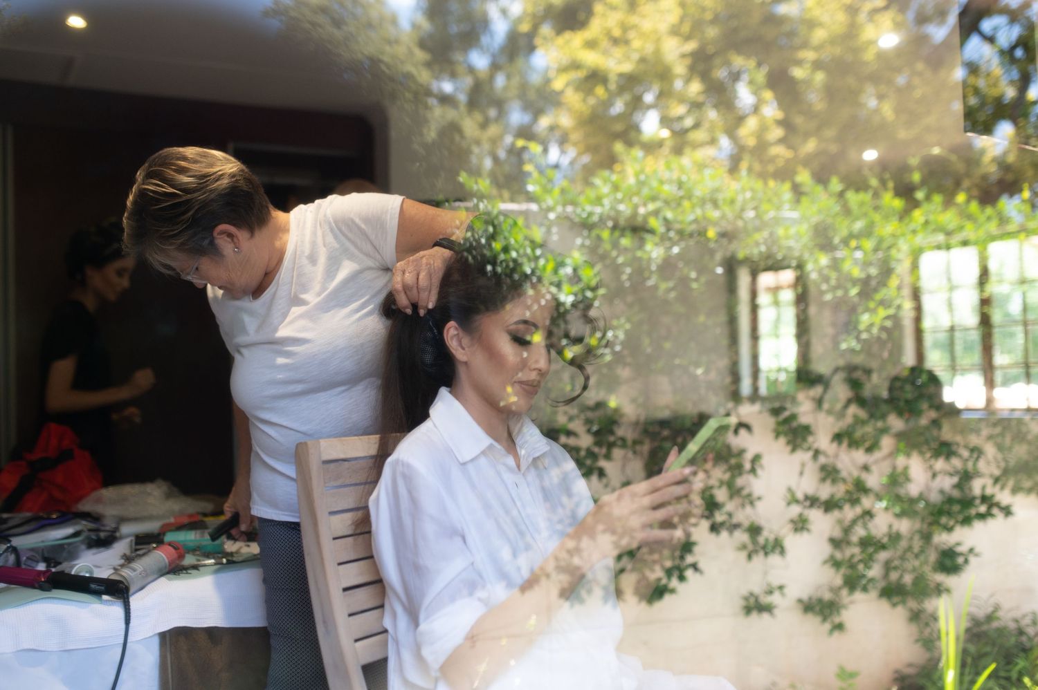 Behind-the-scenes wedding preparation moment with bridal styling in natural light.