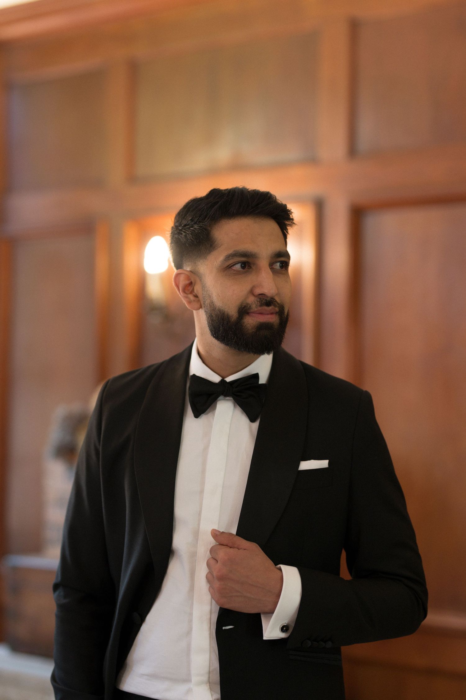 Portrait of a formally dressed person in a classic tuxedo and bowtie.