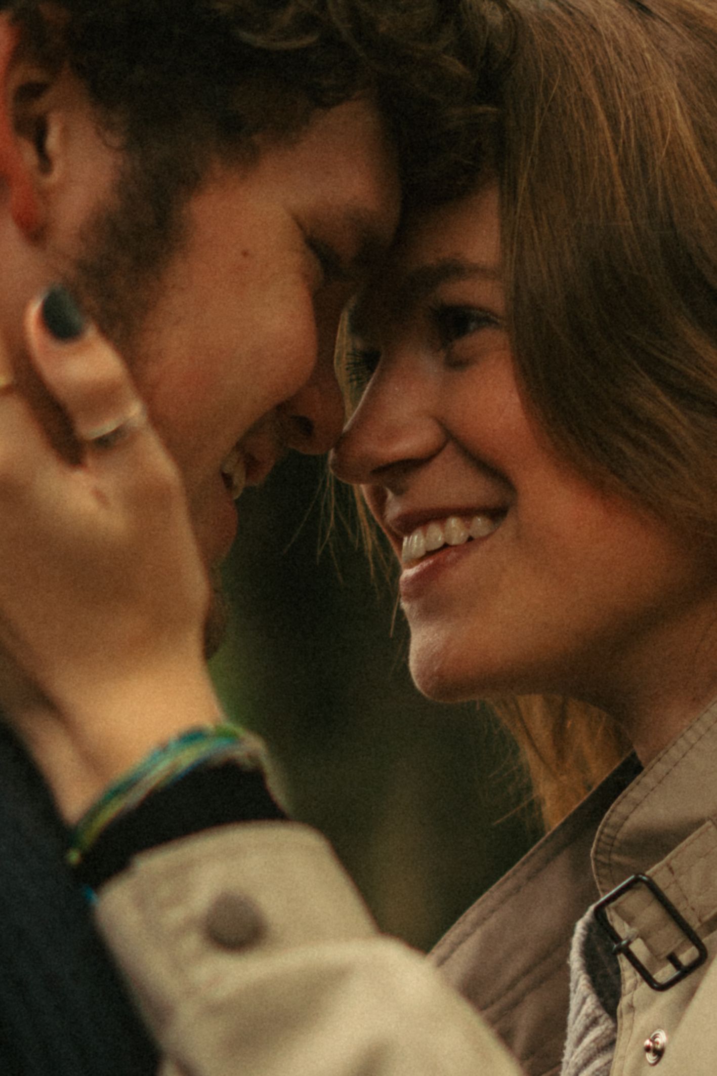 Two people sharing an intimate moment while smiling.
