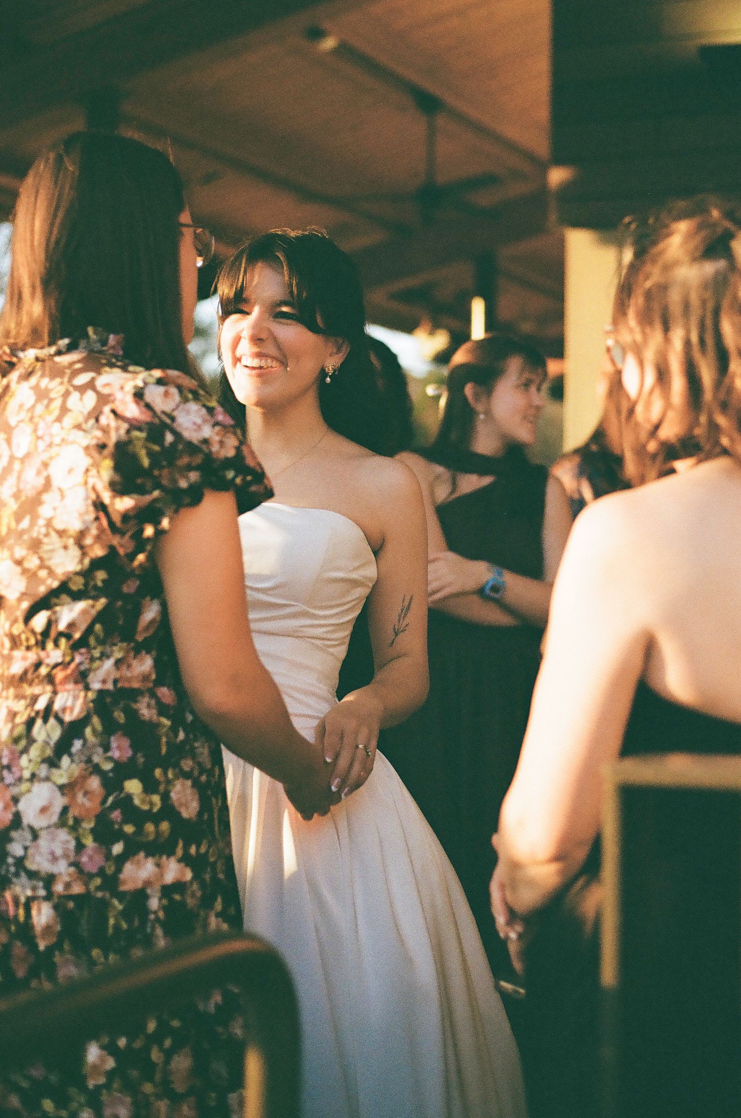 A wedding reception scene with guests in formal attire mingling indoors.