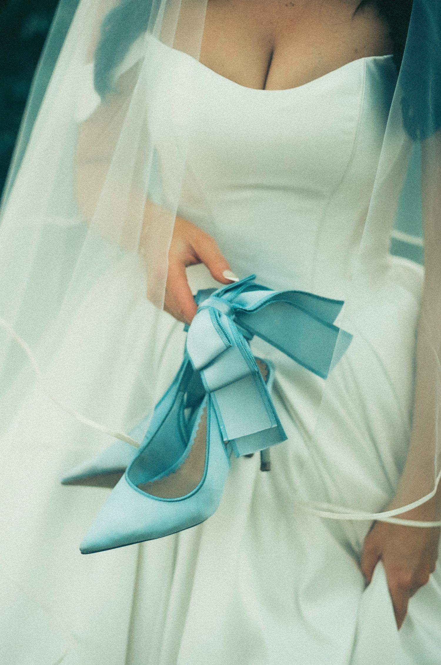 Light blue satin bow high heel shoes styled with a white dress create an elegant bridal fashion statement.