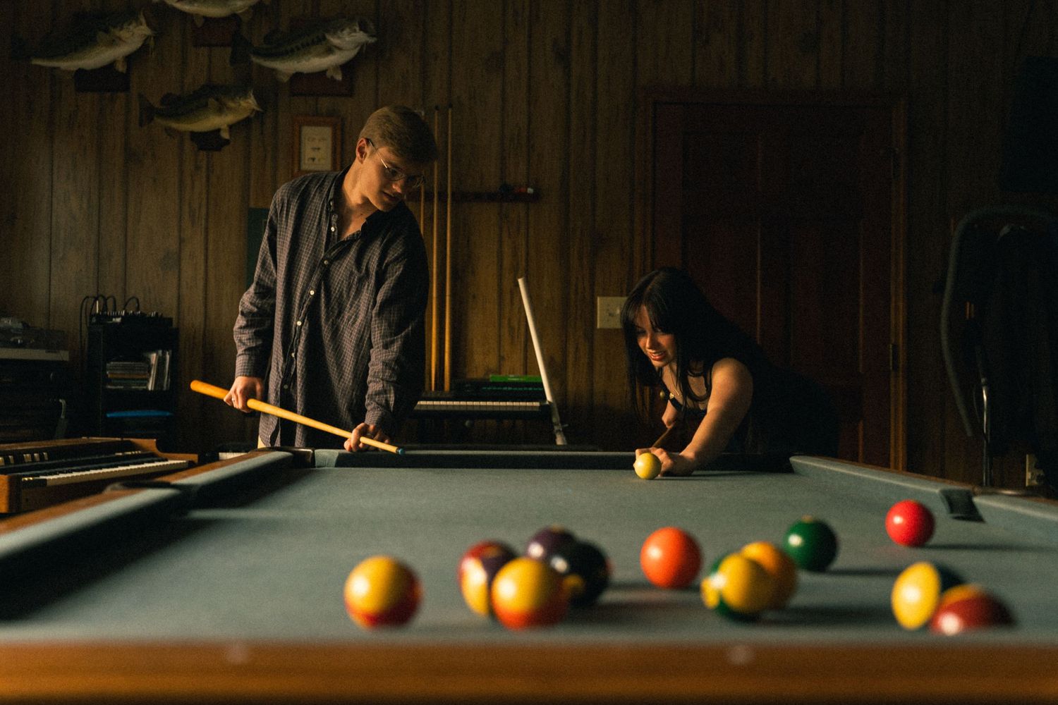 Pool table with colorful billiard balls arranged in dramatic low-key lighting.