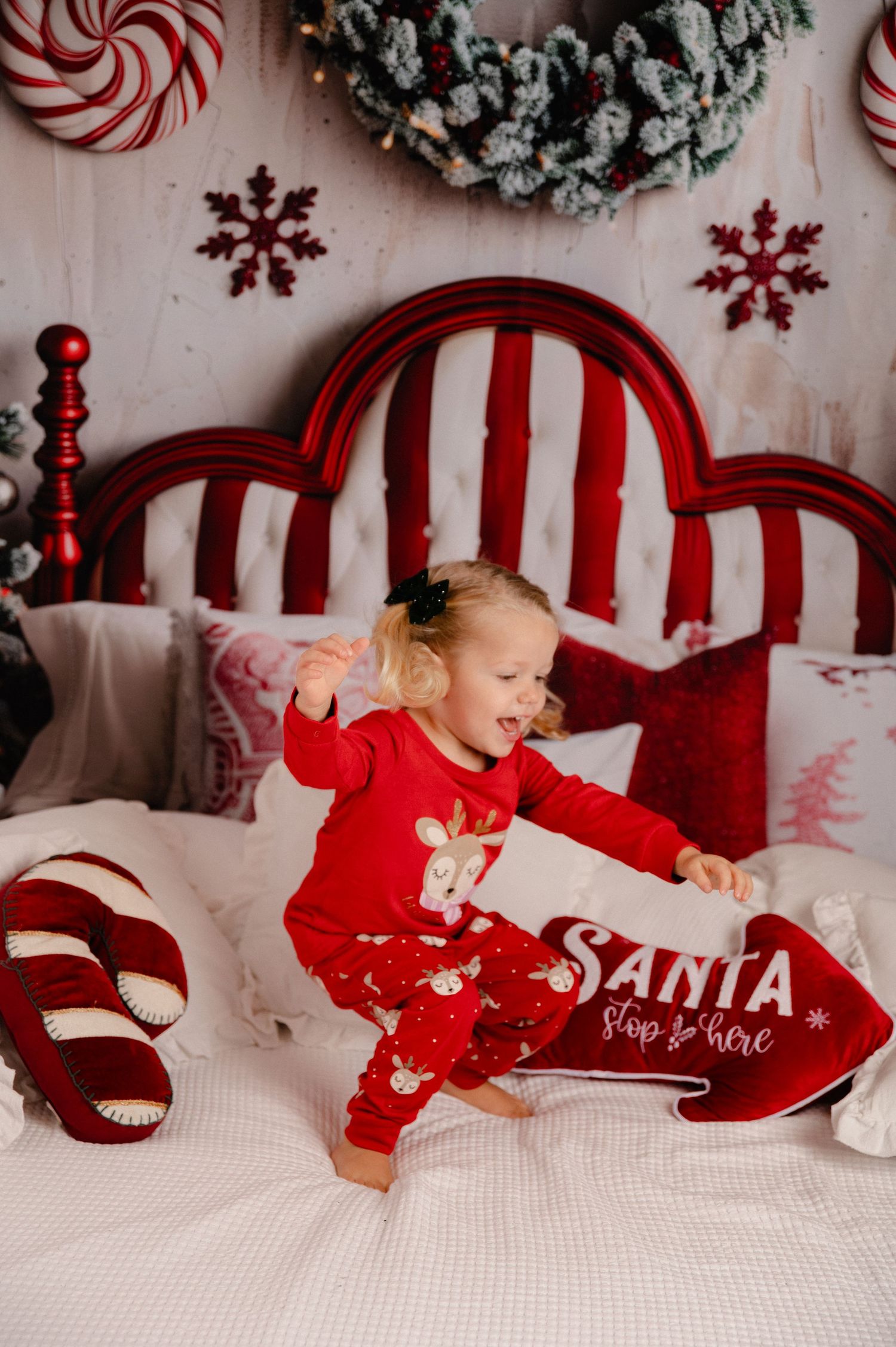Festive Christmas bedroom scene with red and white striped headboard, candy canes, and holiday decorations.