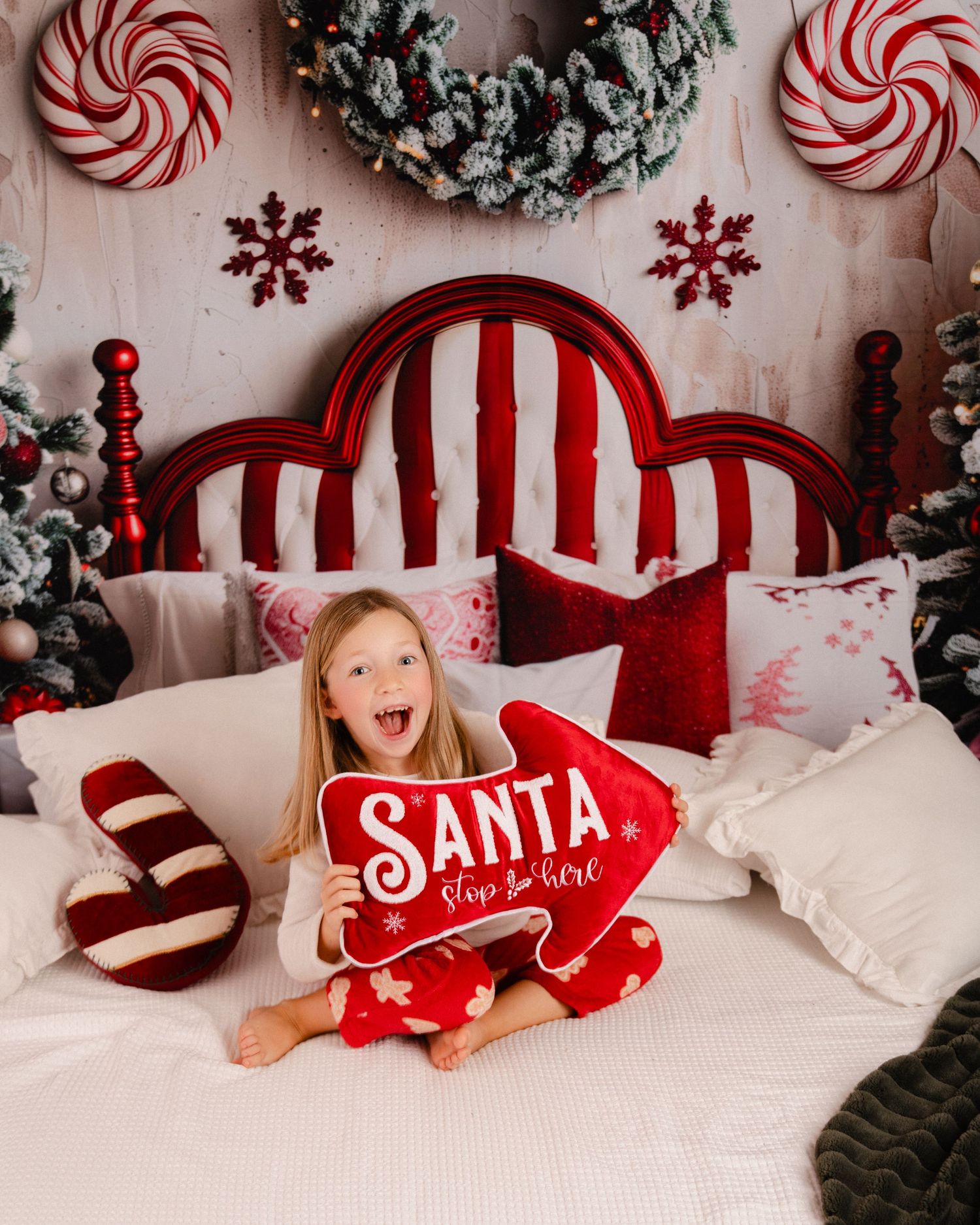 Festive Christmas photo setup with red and white candy cane decorations and snowflakes against a light backdrop.