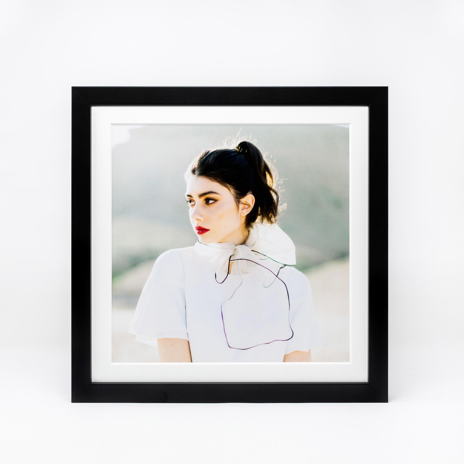 A minimalist gallery wall layout featuring black and white framed portrait photographs in a clean, modern arrangement.