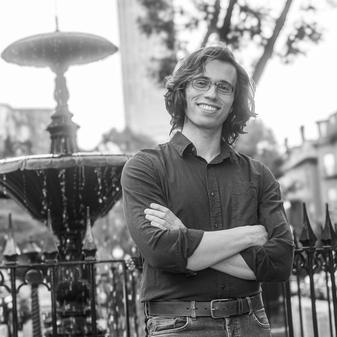 Black and white photo collage showing a person in casual attire sitting and posing against a decorative iron fence.