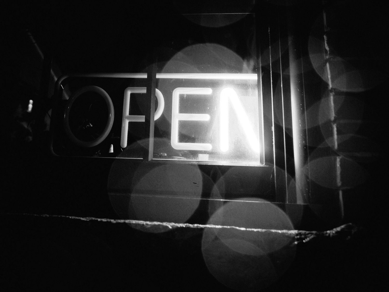 A series of black and white film noir style photographs showing dark urban scenes with dramatic lighting and shadows.