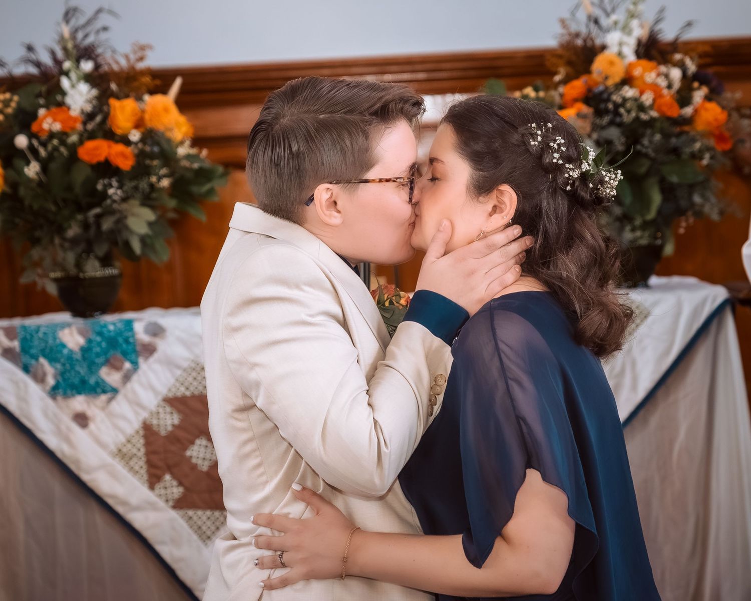 A romantic sequence of wedding photos showing a couple sharing tender kisses in front of orange floral decorations.
