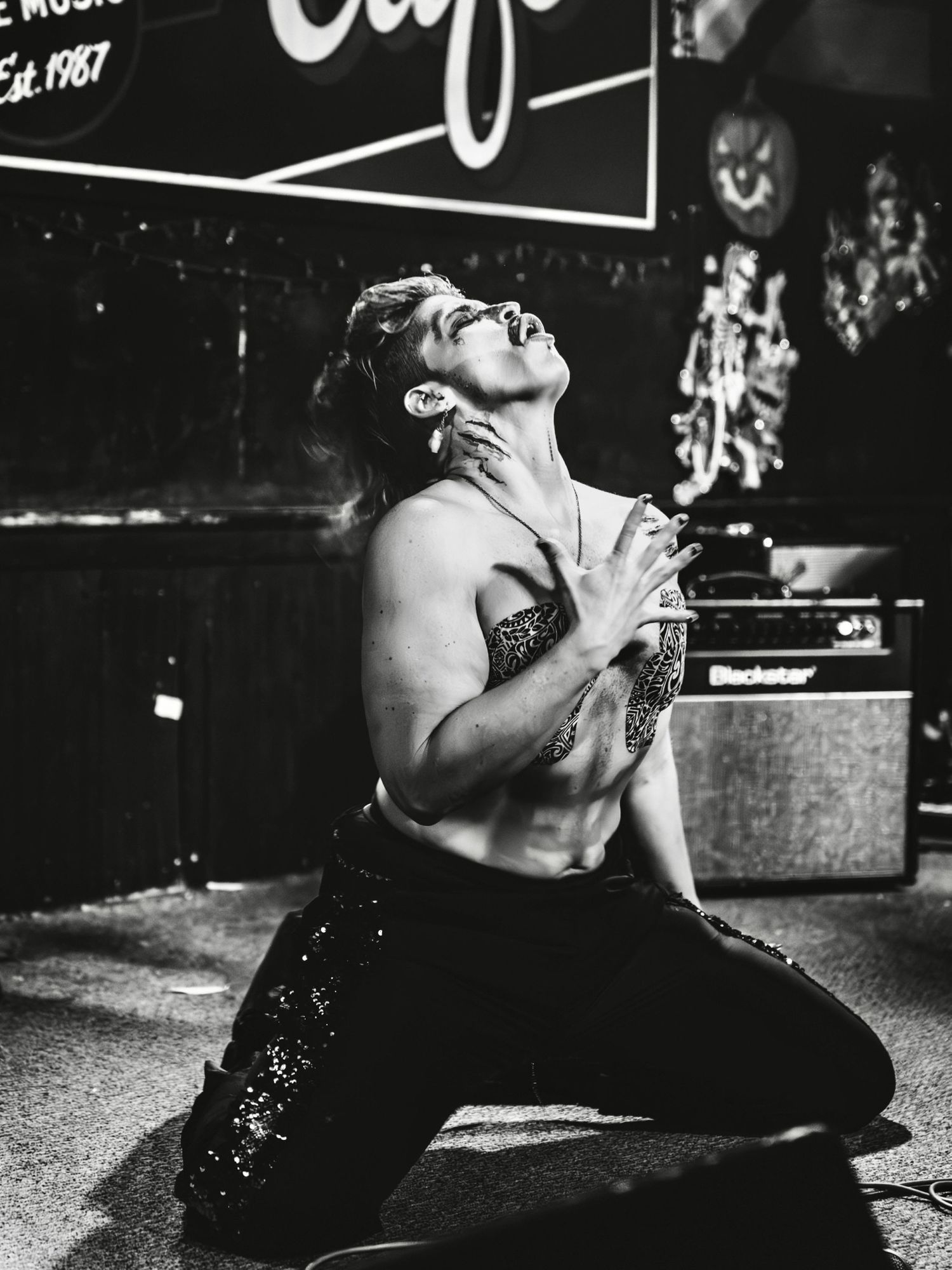 A black and white photo series showing someone performing on stage in dramatic lighting and poses.