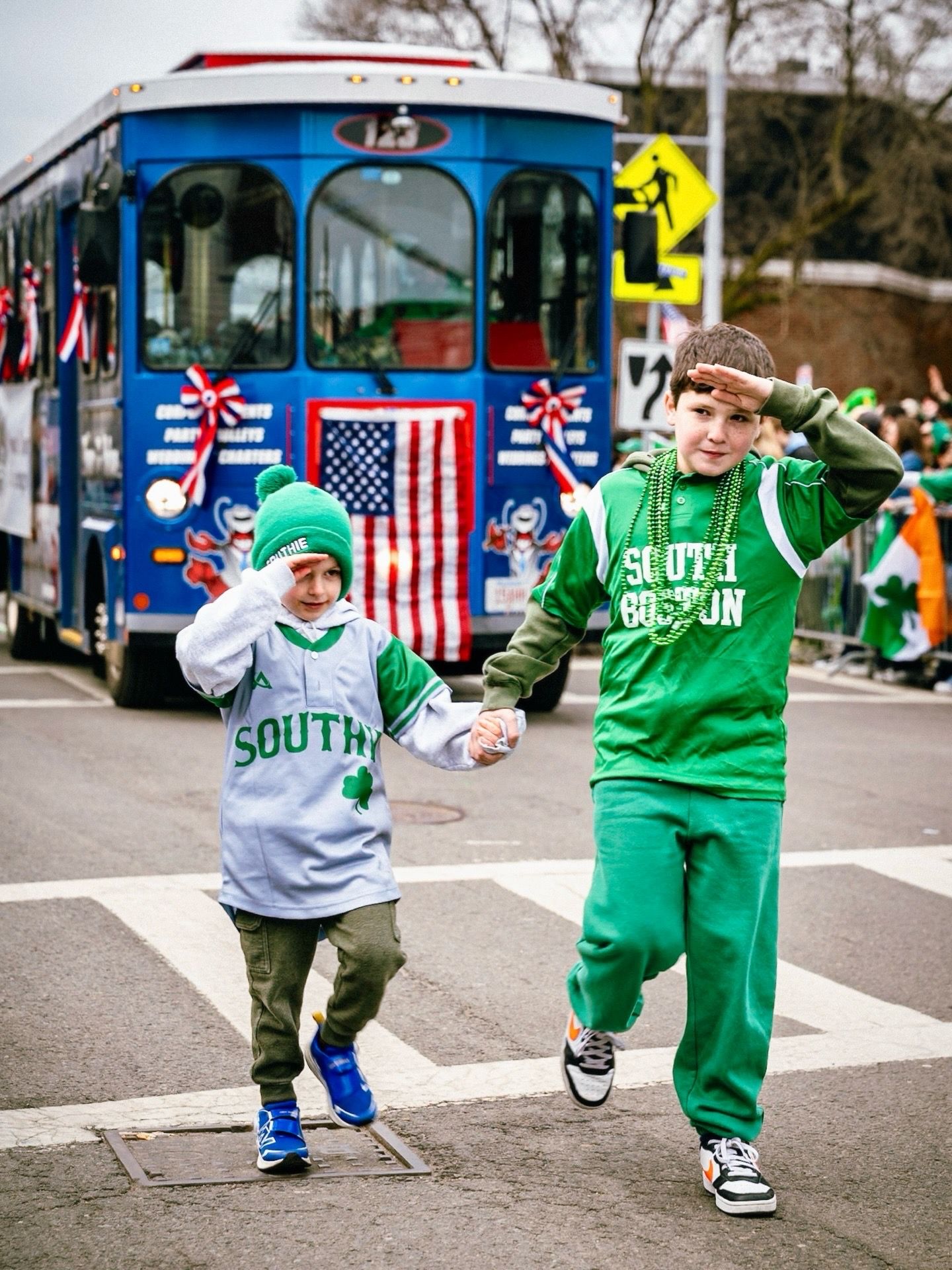 A sequence of dancers in green and gray outfits performing synchronized street dance moves in front of American flags.