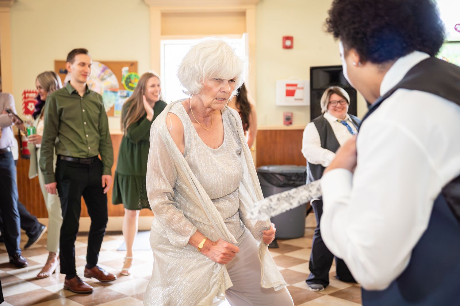 People practicing dance moves in a bright indoor studio space with wooden floors and white walls.