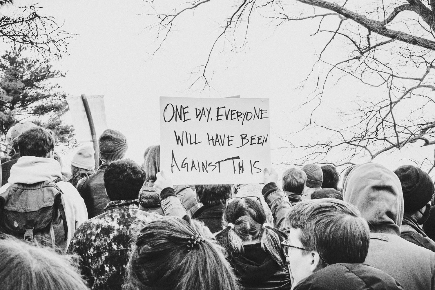 A black and white panoramic photograph shows a crowd gathered at an outdoor protest or demonstration.