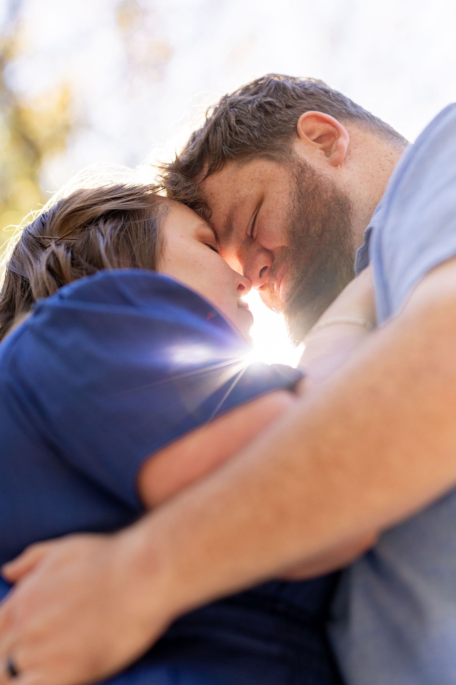 Intimate sunlit portraits of couple in natural outdoor setting.