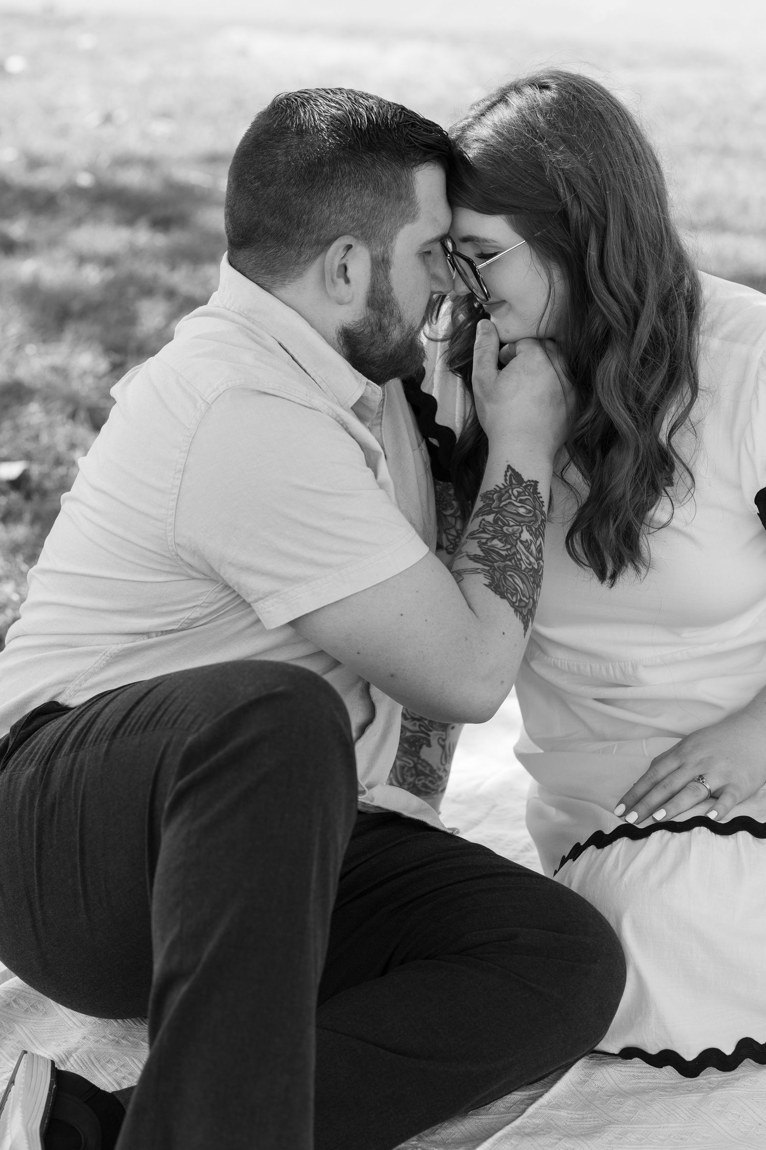 Black and white series of a romantic couple sitting together on a blanket.