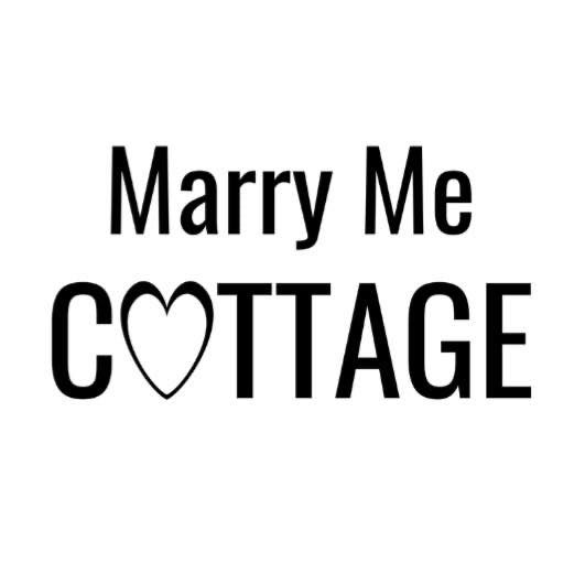 Black text logo for 'Marry Me Cottage' with a heart symbol integrated into the word 'Cottage'.