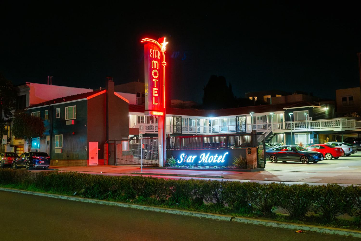 Star Motel with glowing neon signs illuminated at night, featuring classic roadside architecture and parking lot.