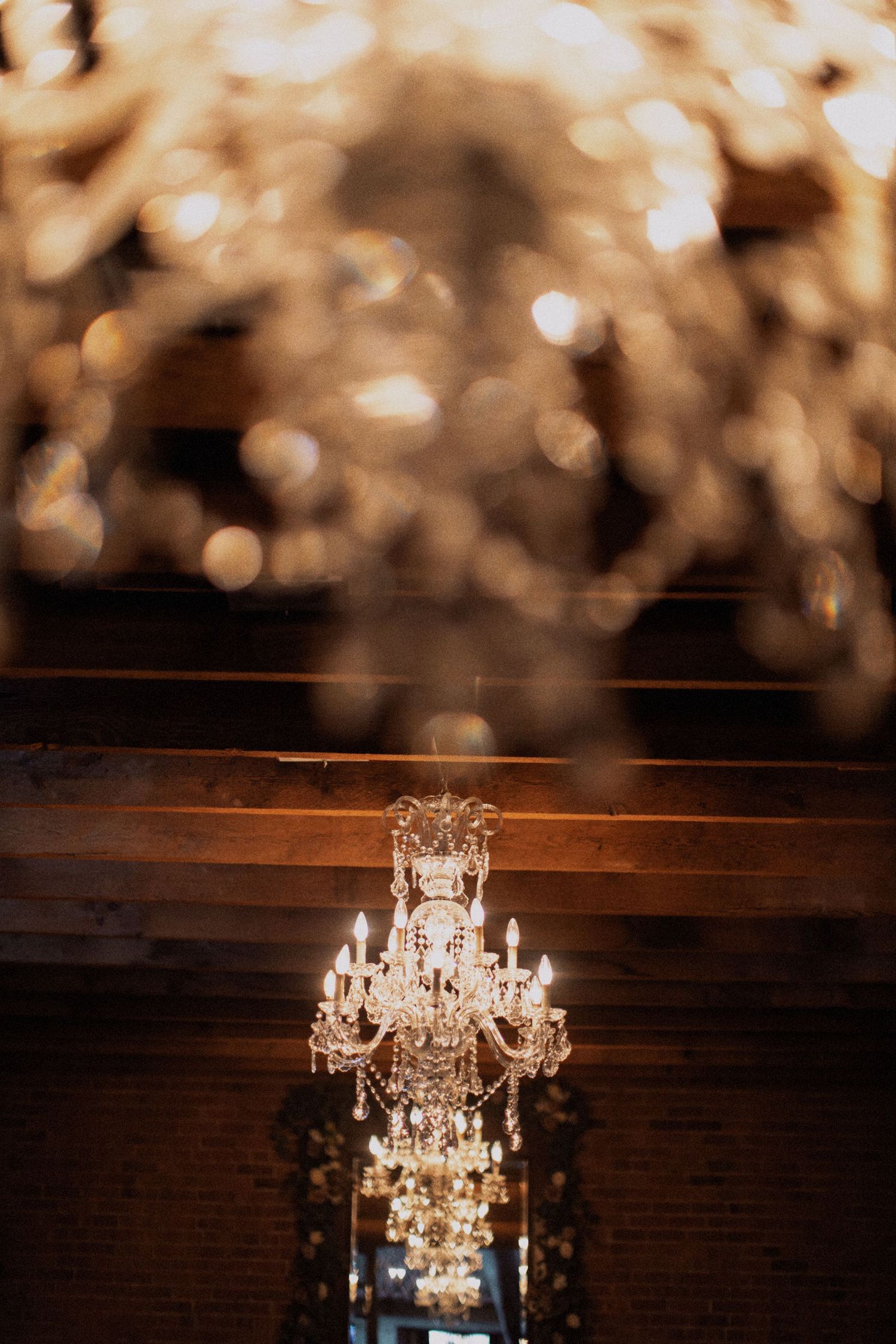 Crystal chandelier photographed with bokeh effect in warm lighting.