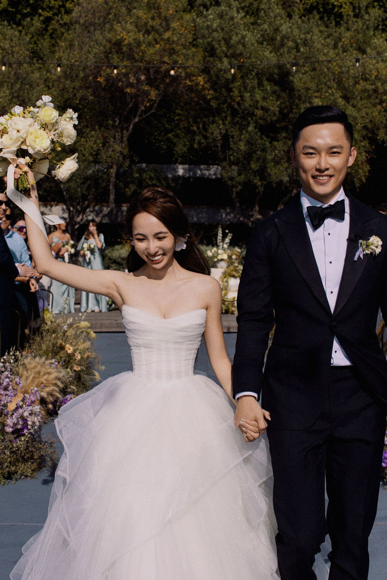A joyful wedding couple celebrating on their outdoor ceremony platform.
