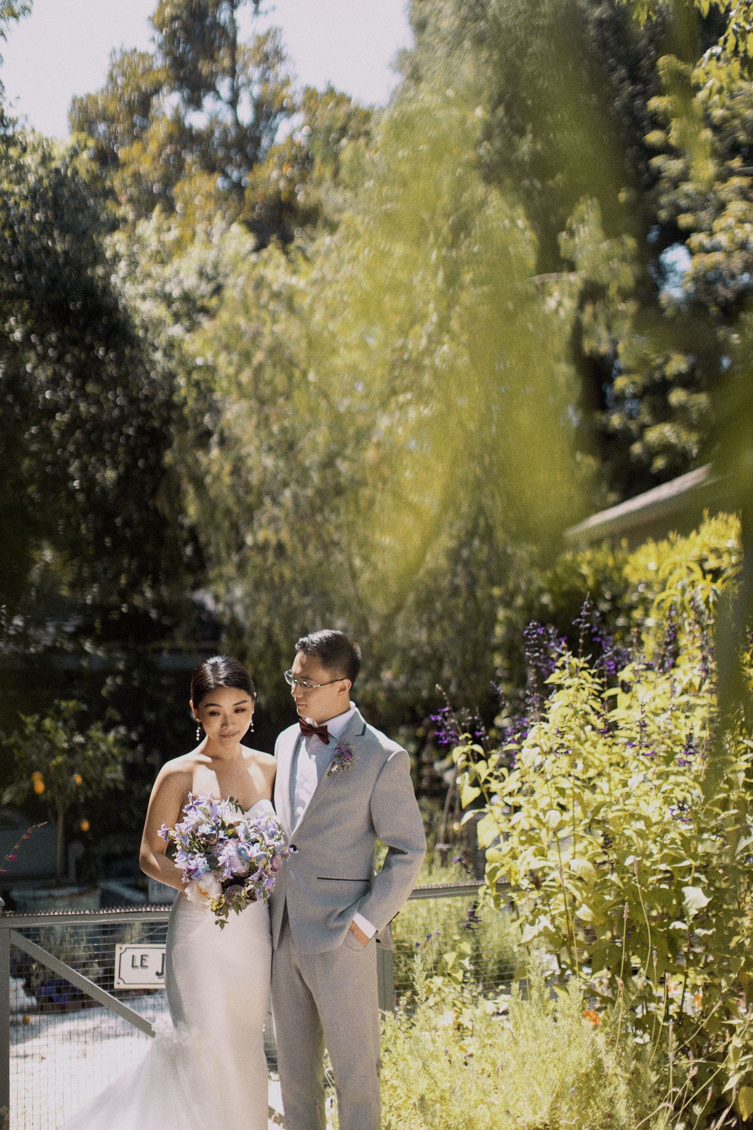 Garden wedding scene with lush greenery and sunlit pathway.