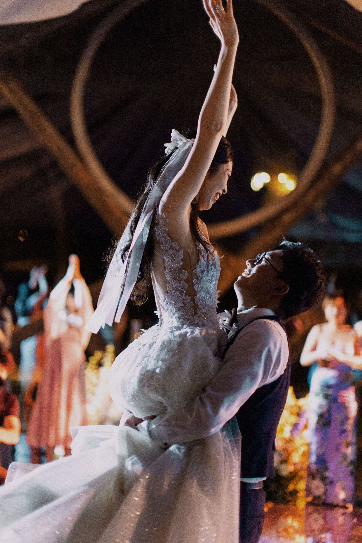 A couple performing a dramatic dance lift during their wedding reception.