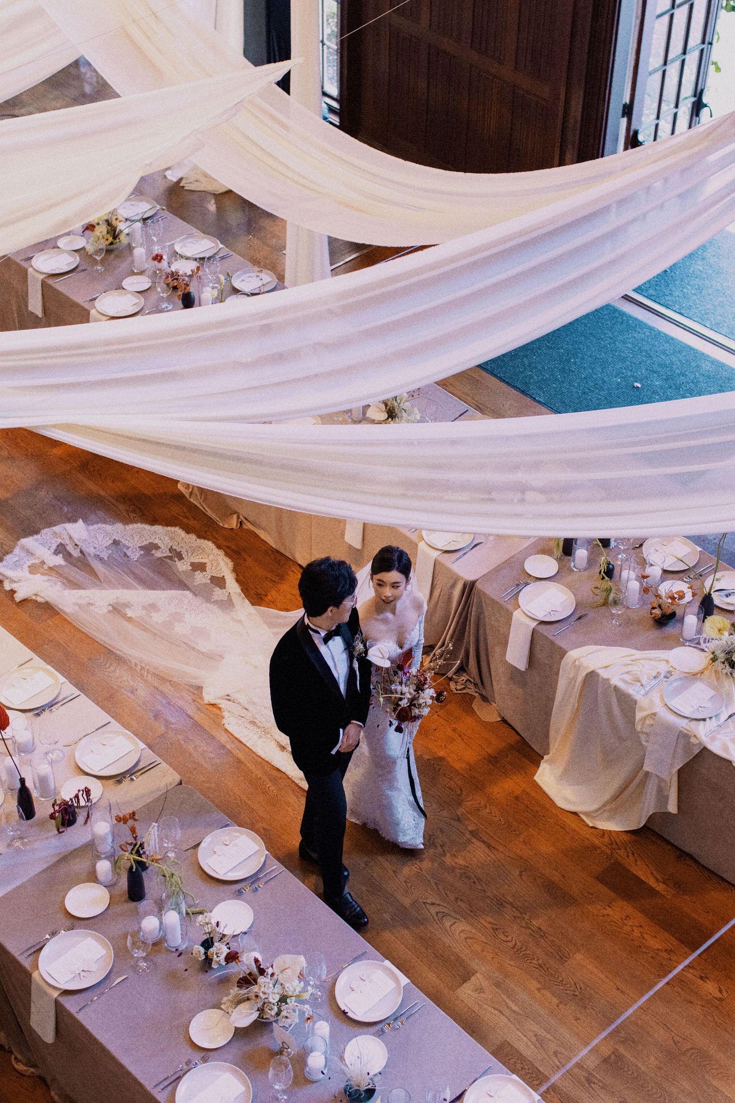 Aerial view of a wedding reception setup with white draping and elegant table settings.