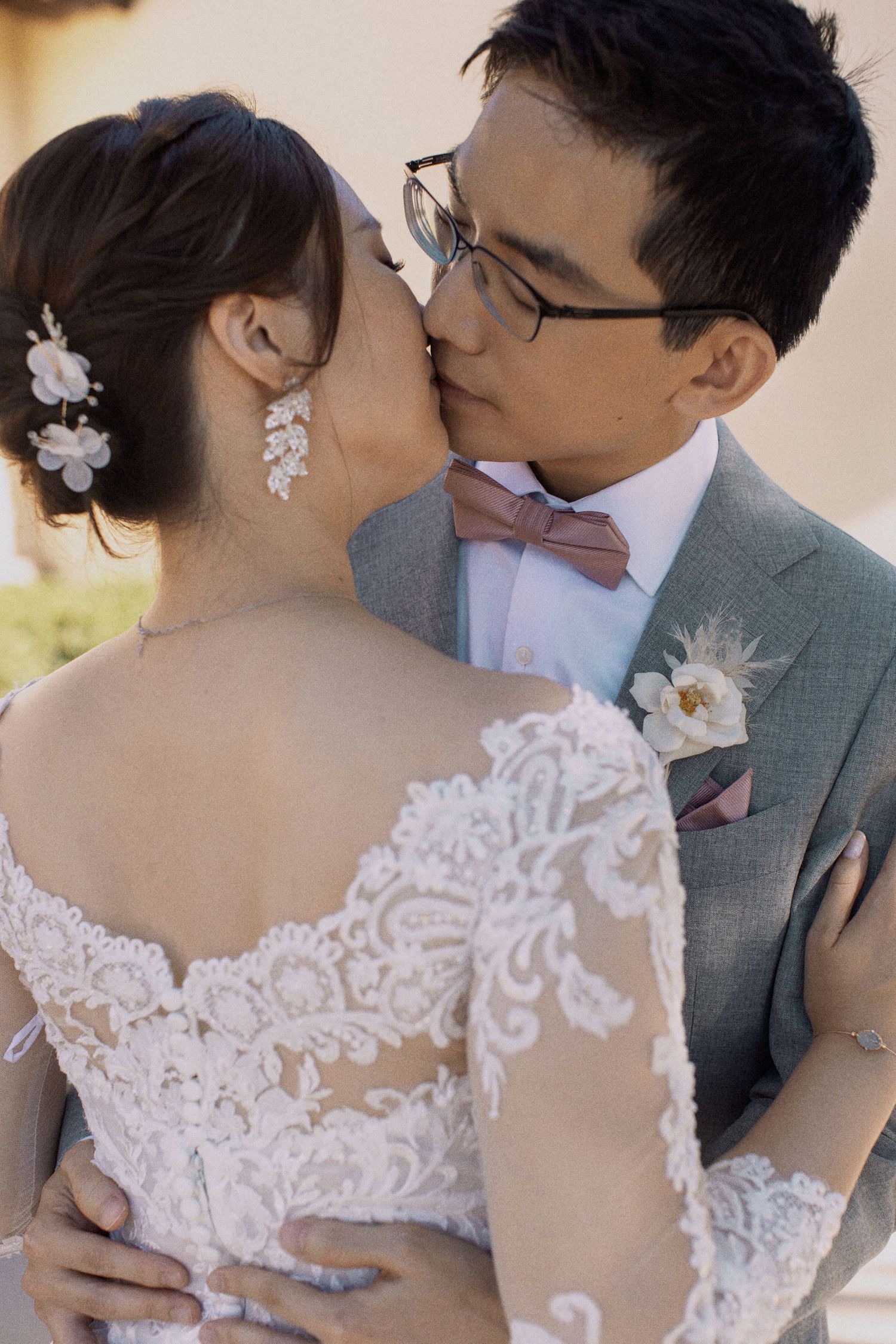 Intimate moment between newlyweds in elegant wedding attire.