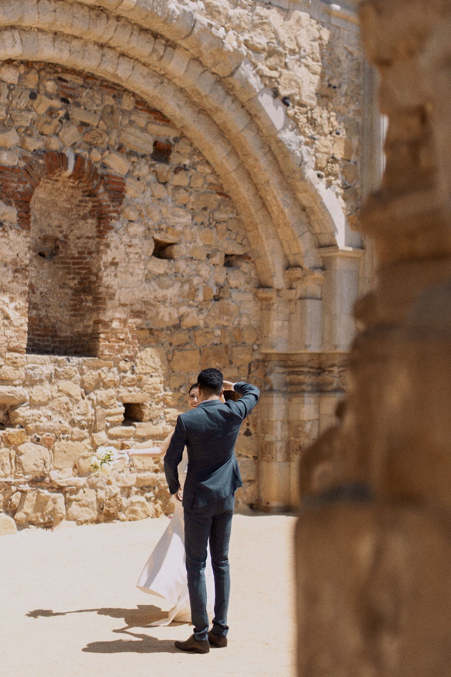 Photographer capturing shots in historic stone archway.