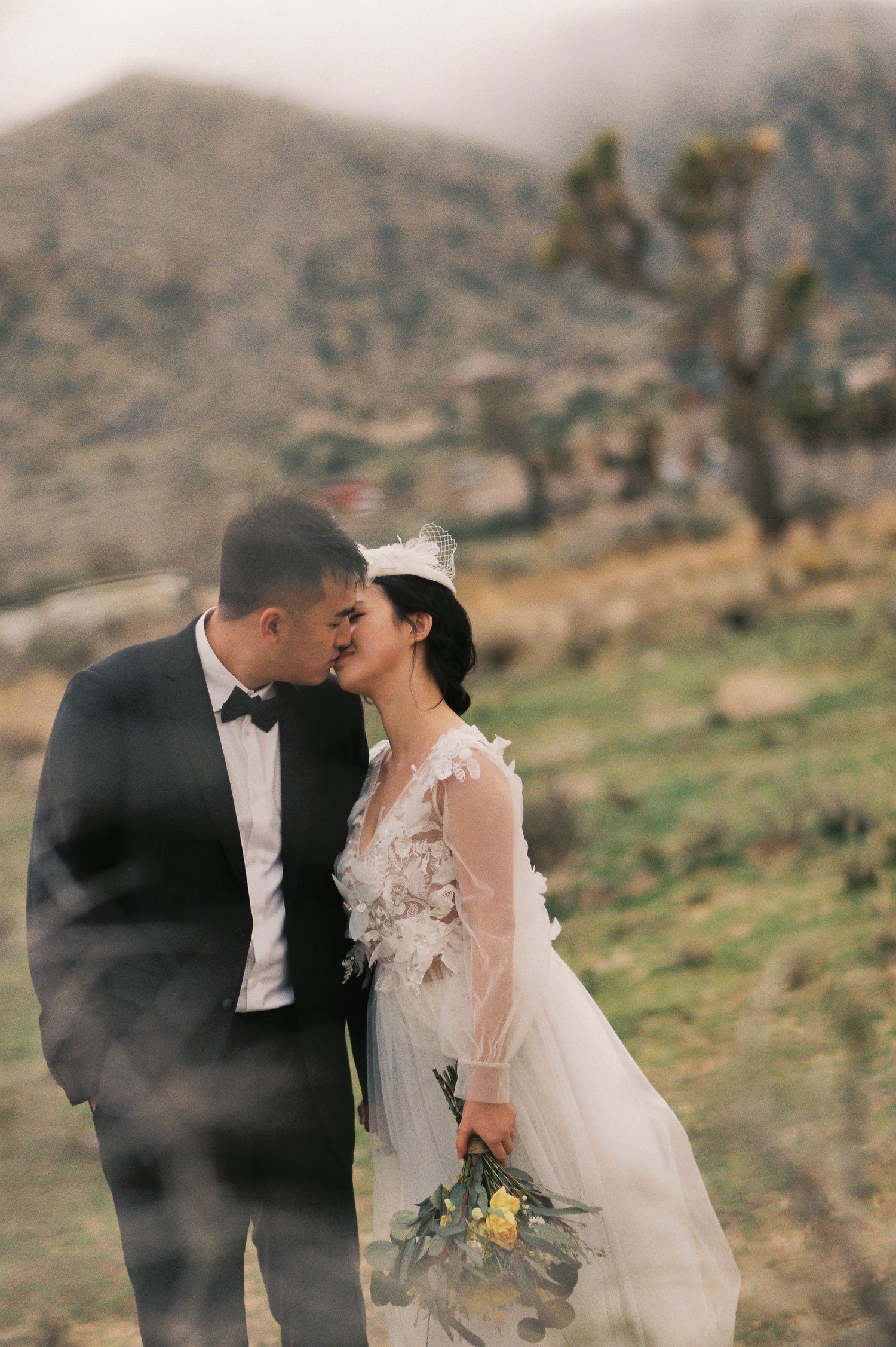 A romantic wedding moment captured against a desert mountain backdrop.