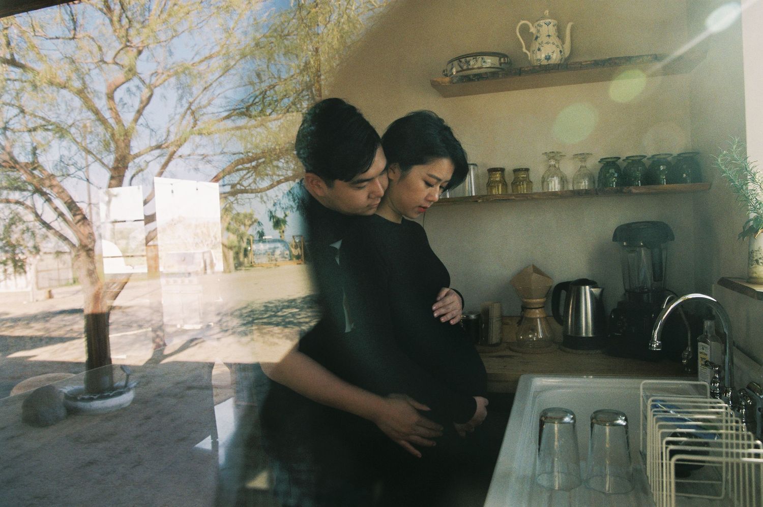 Intimate moment in a sunlit kitchen with rustic decor.