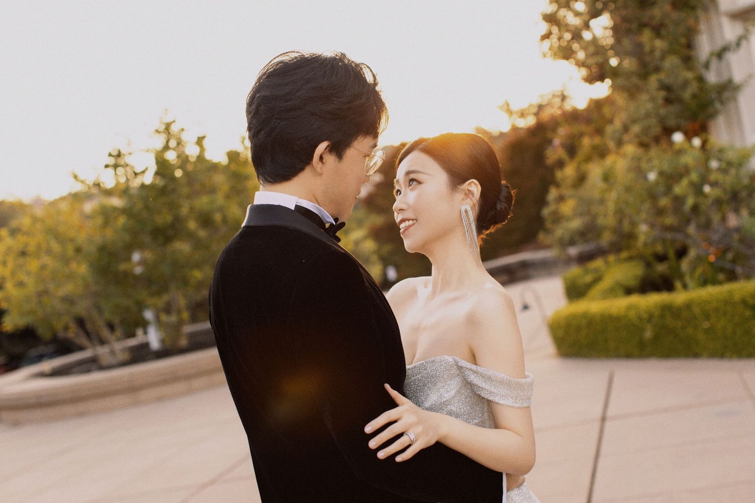 Tender moment between a couple in formal attire sharing an intimate moment at sunset.