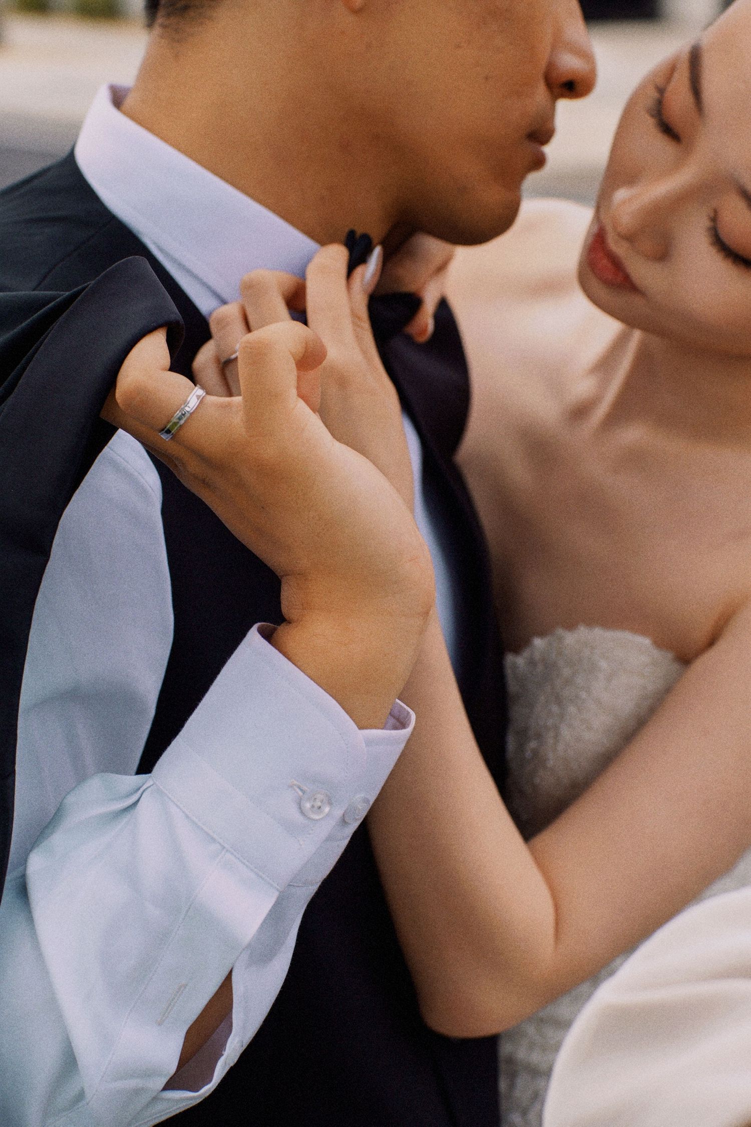 A tender moment between newlyweds as the bride adjusts the groom's bowtie.