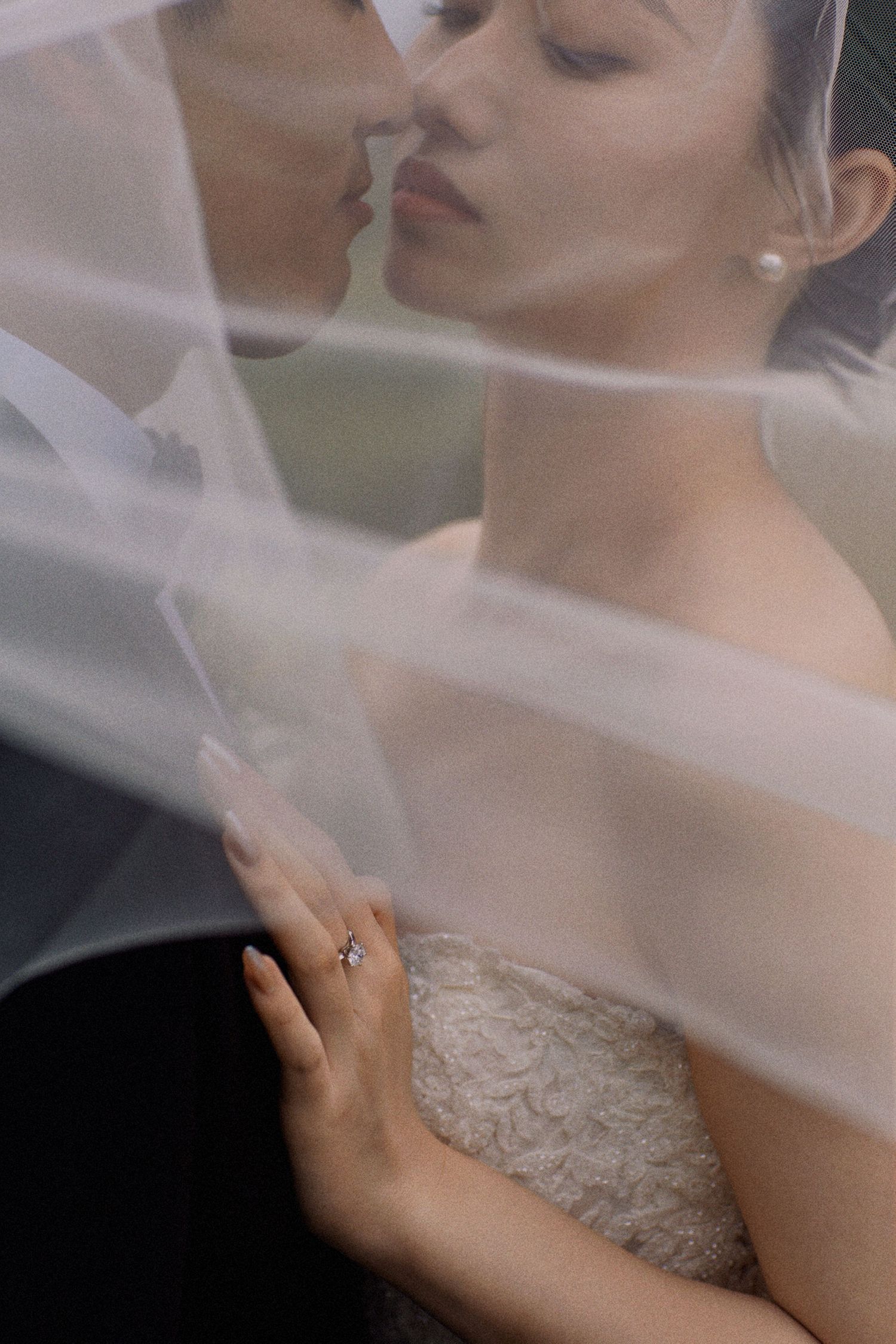 An intimate portrait of a bride and groom sharing a tender moment under a delicate veil.
