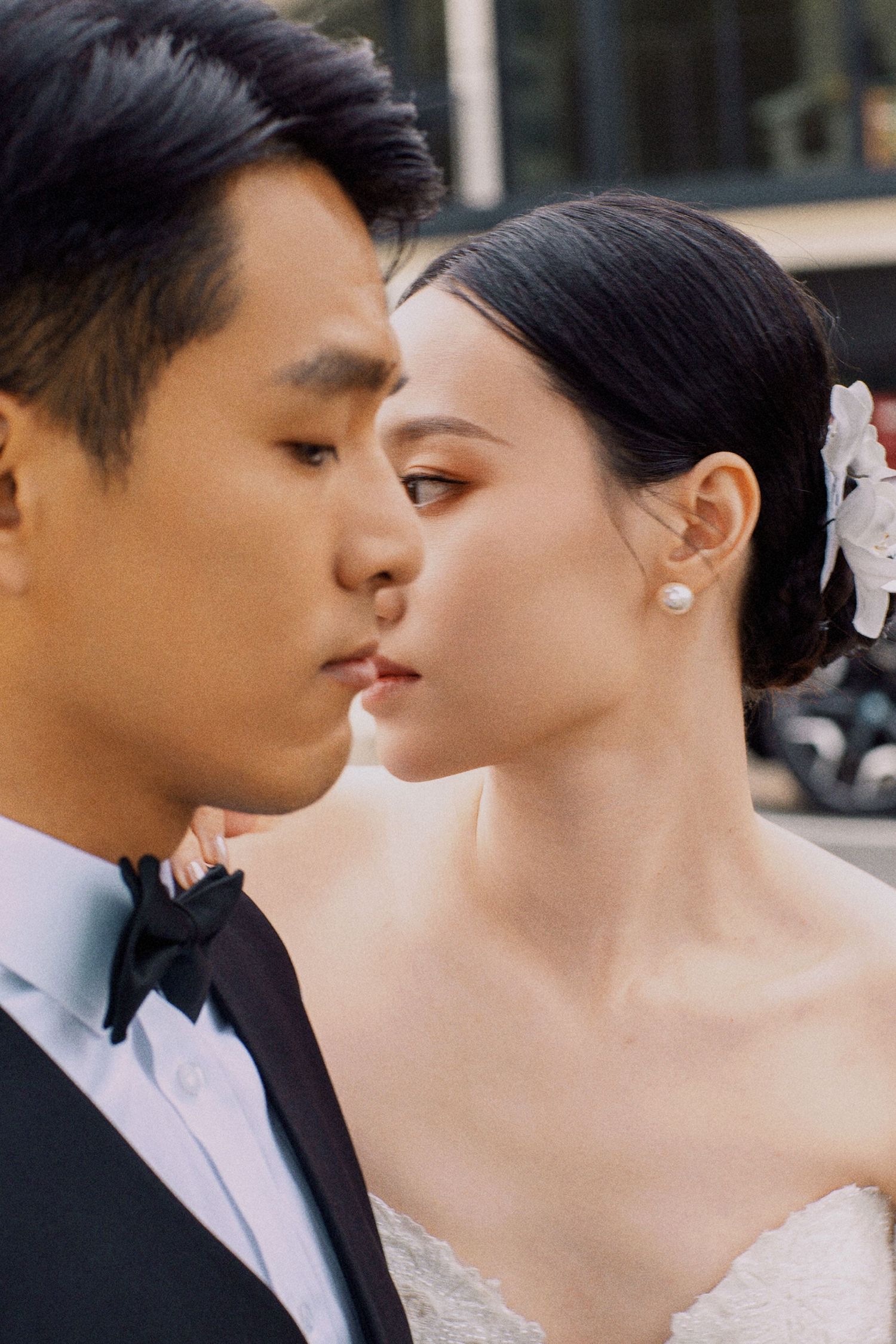 An elegant wedding couple in formal attire sharing an intimate close-up moment.