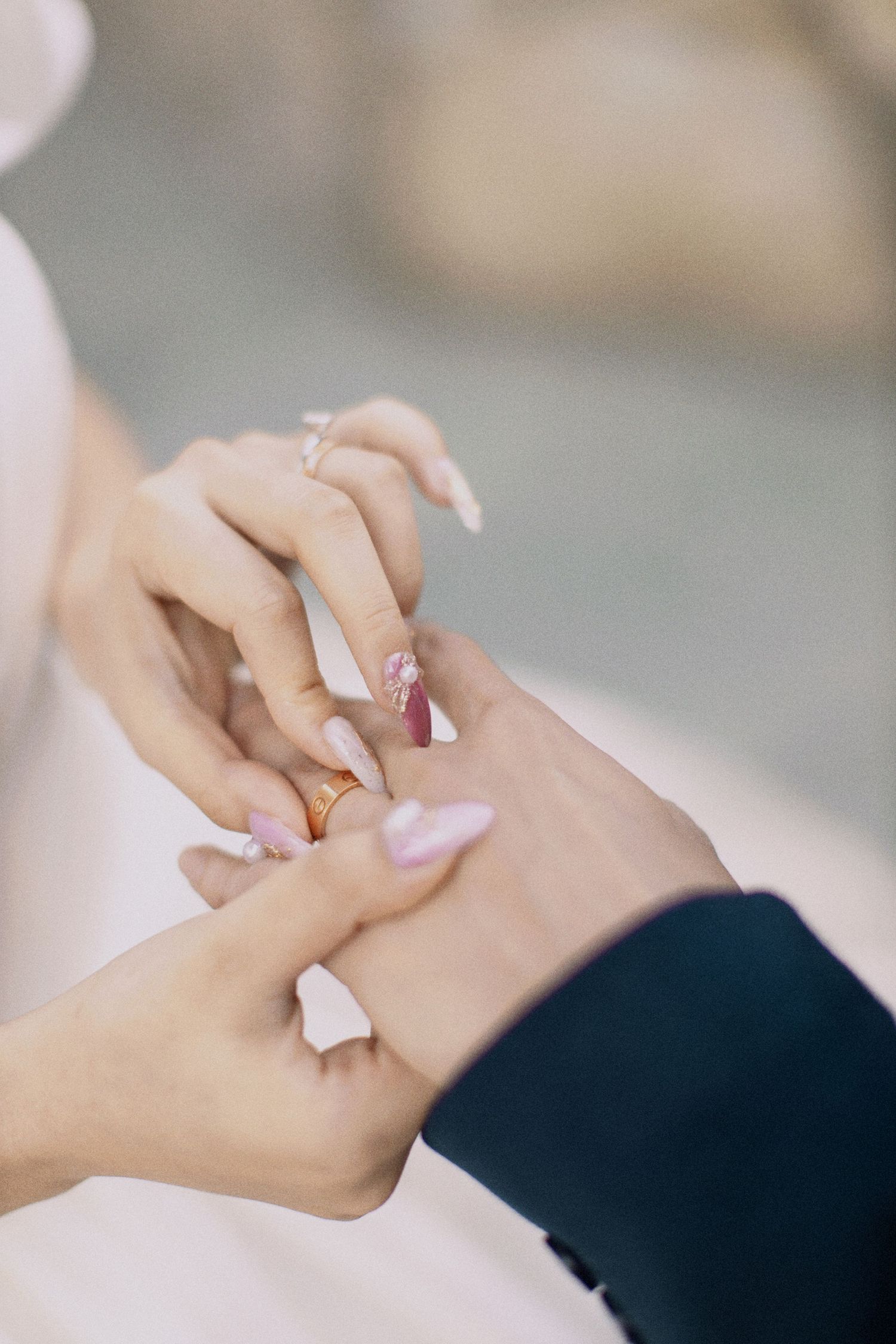 Close-up of hands exchanging wedding rings during ceremony.