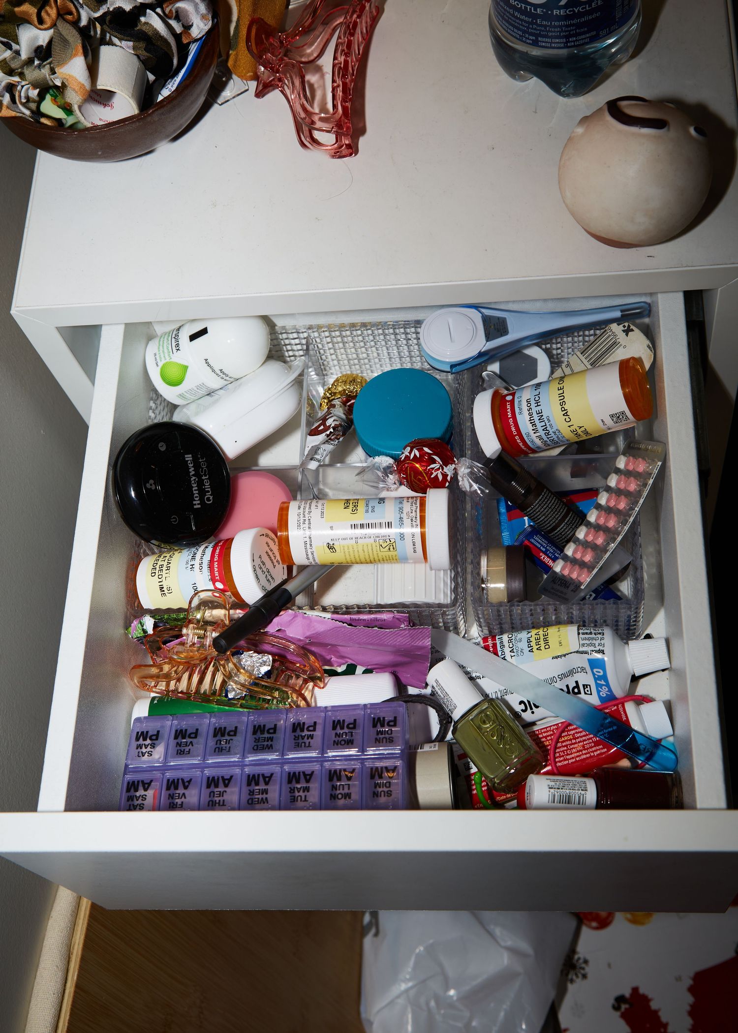 Drawer filled with assorted medication bottles and health supplies.