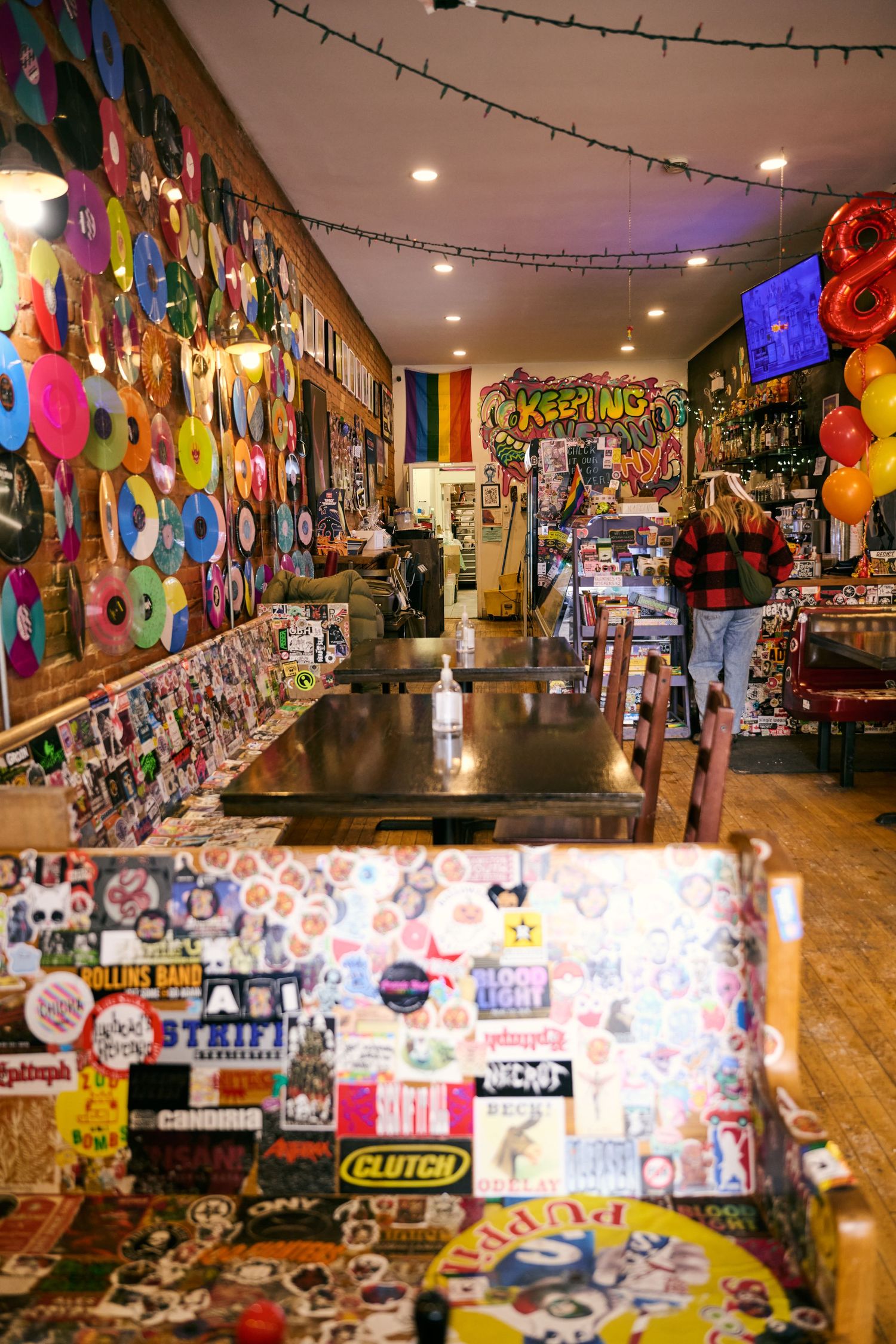 A colorful retail store interior with walls covered in stickers, decals and merchandise displays.