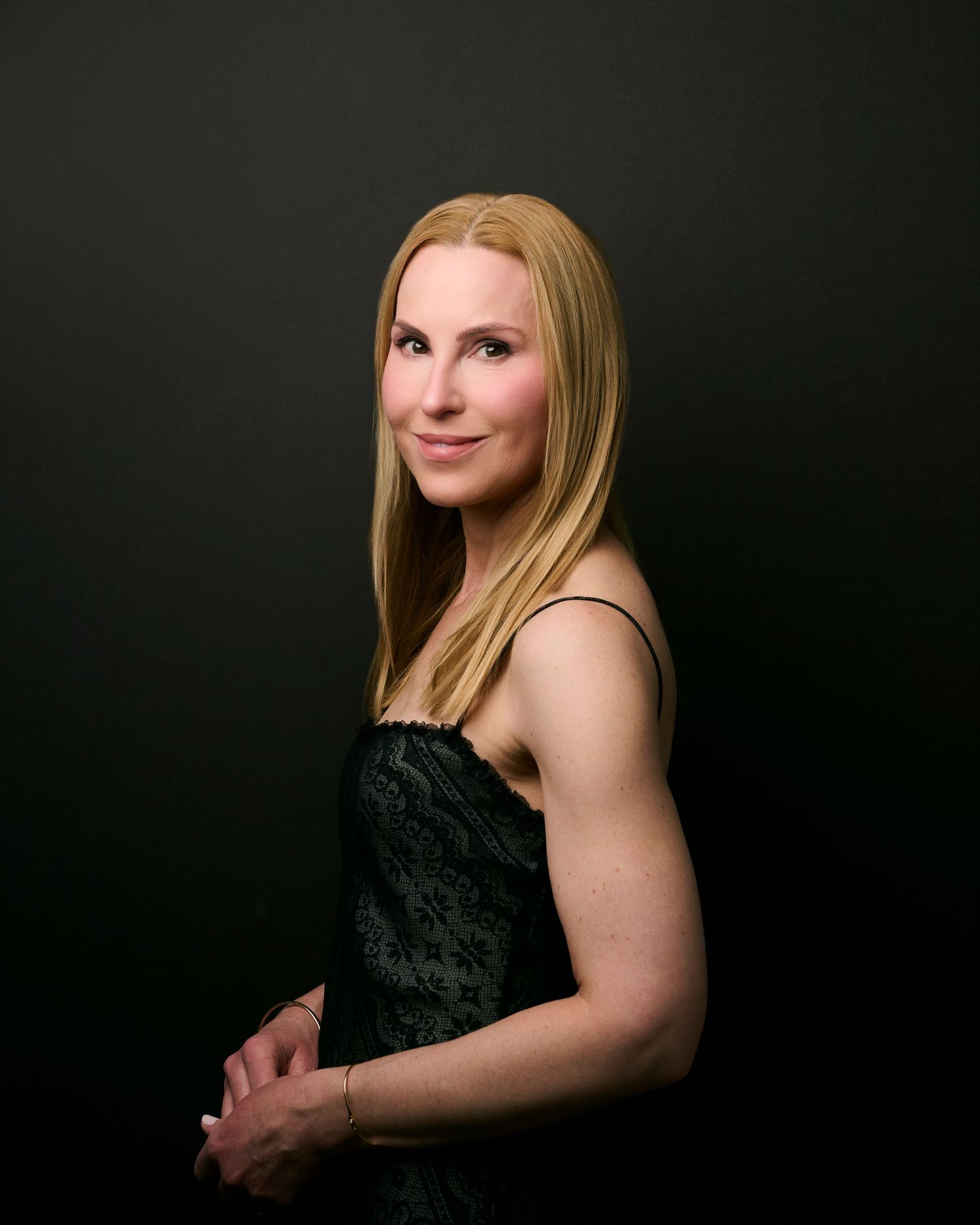 A series of dramatic black and white portraits against a dark background showcasing elegant poses in a black dress.