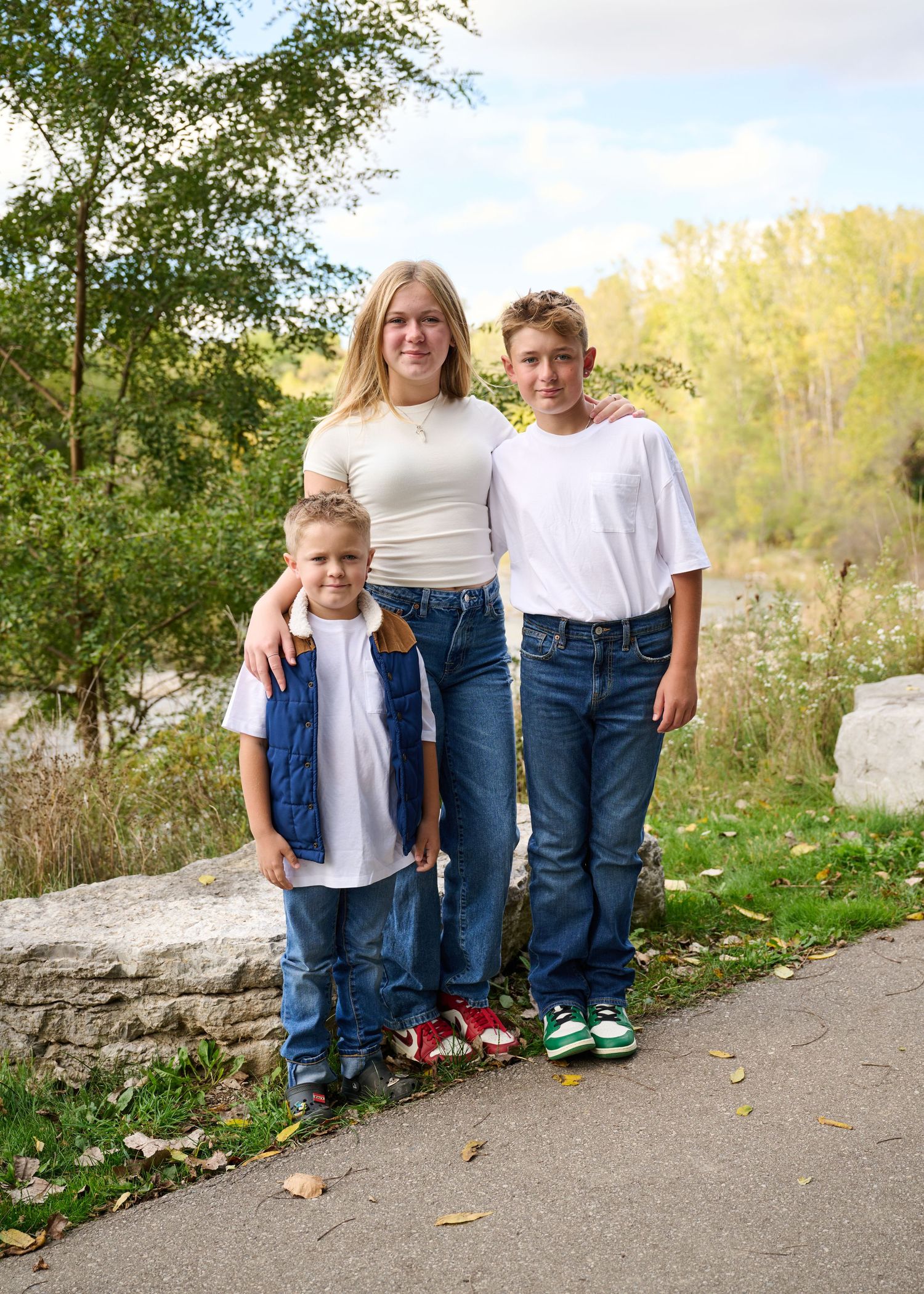 A series of five similar casual outdoor photos taken against a natural backdrop of trees and a stone wall.