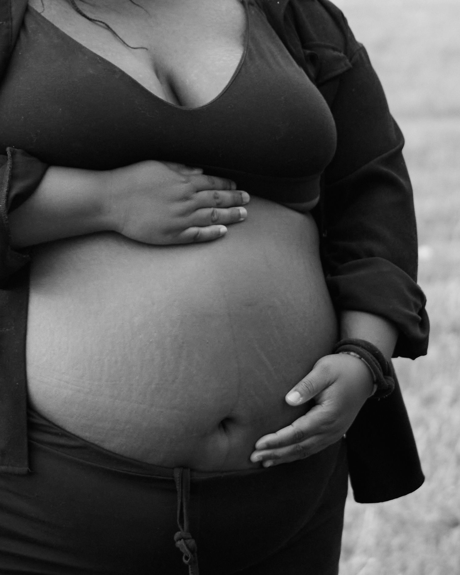 Black and white portraits of pregnant bellies shown with gentle hands cradling them in an artistic progression series.