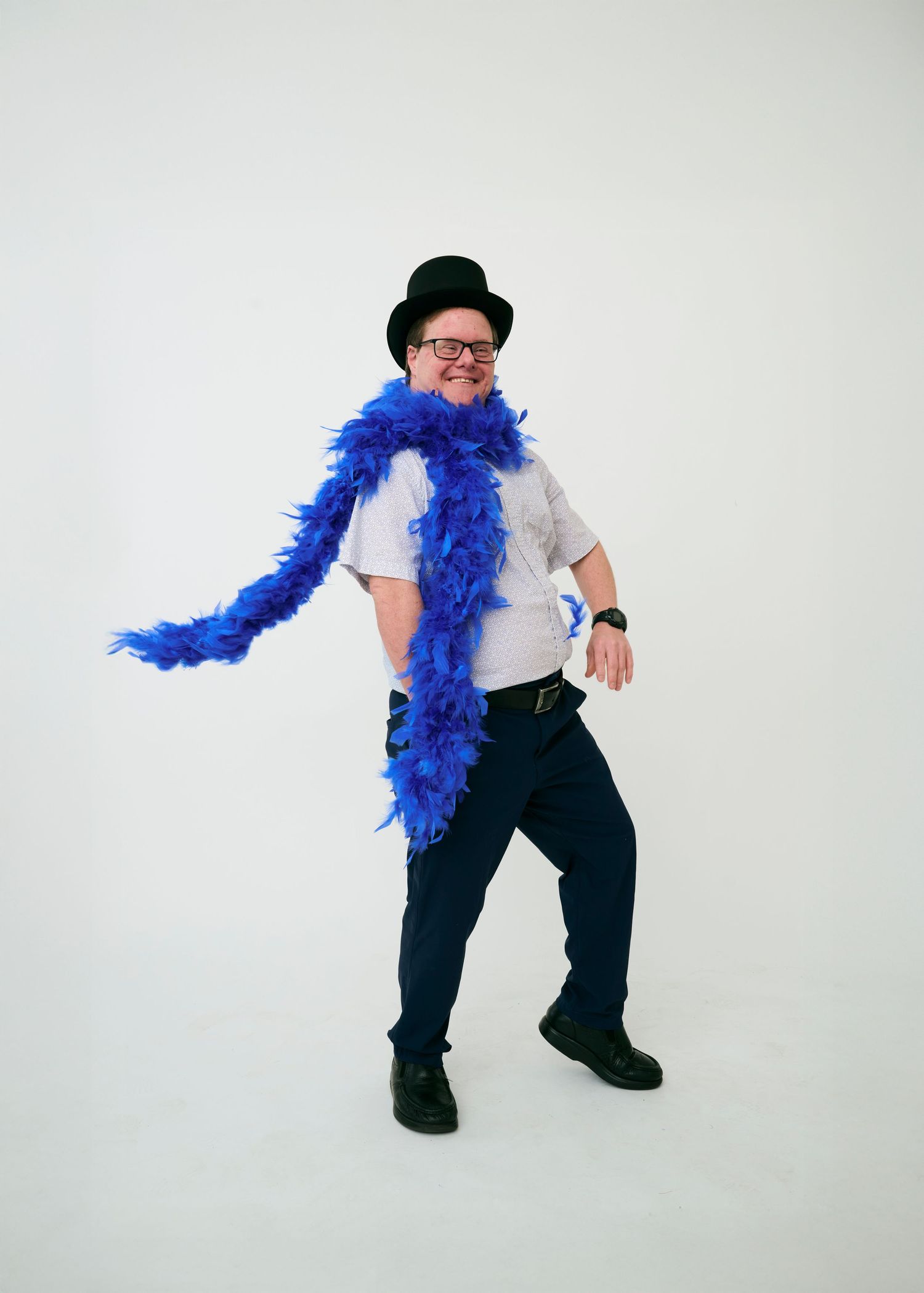 Three dynamic poses showing a performer in white shirt and dark pants with bright blue feather boa against white backdrop.