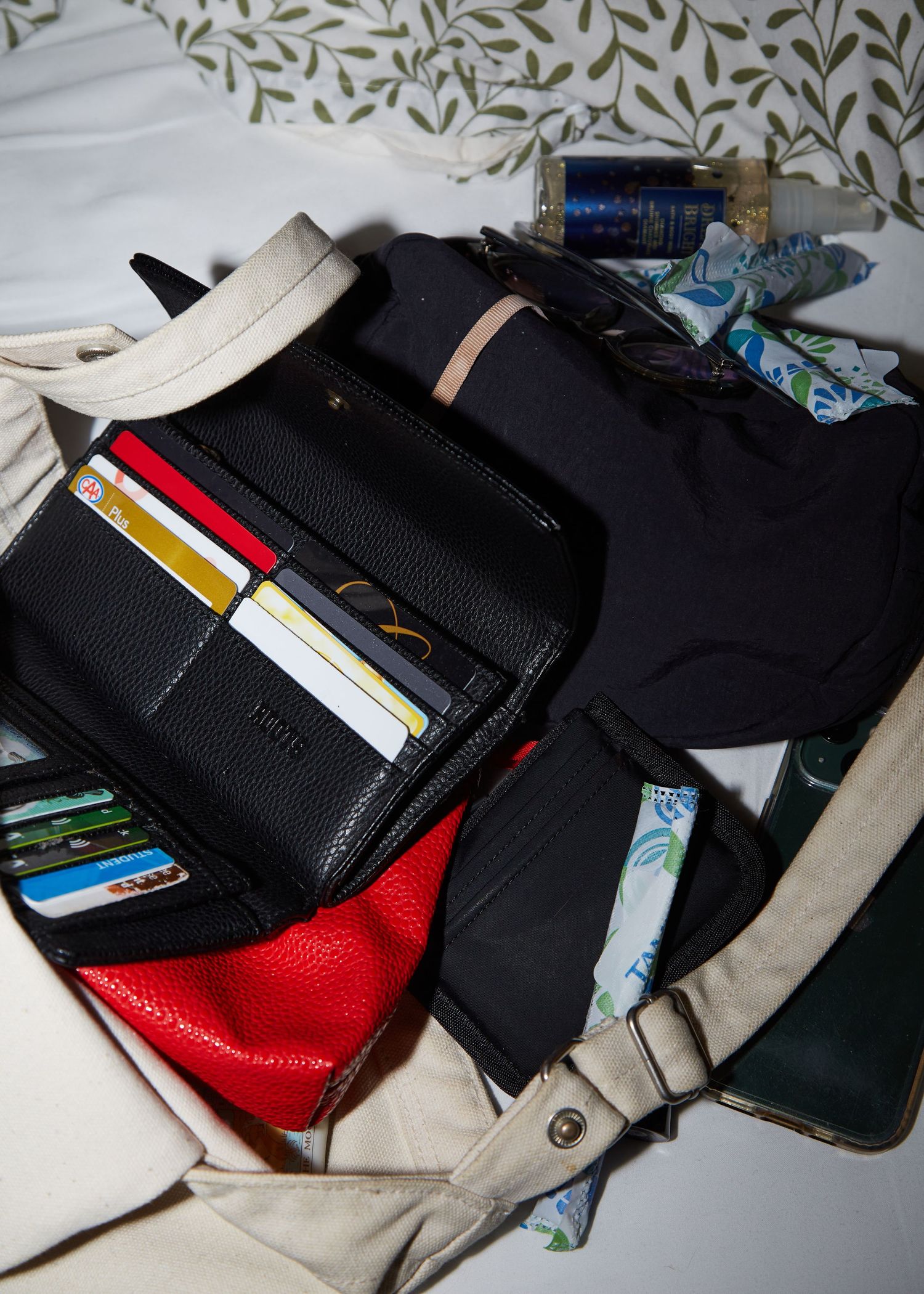 Open wallet showing credit cards and cash compartments with bags in background.