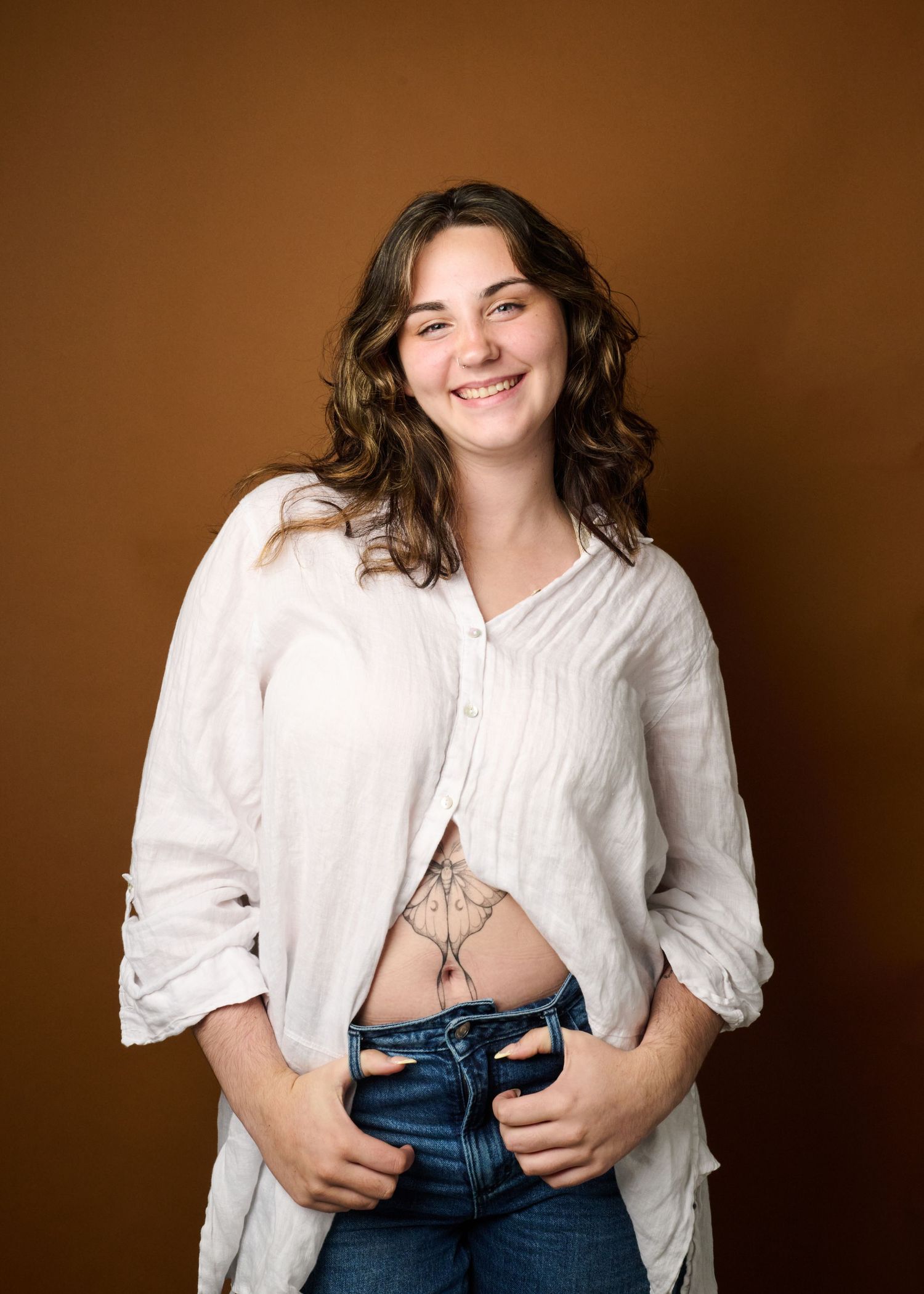 A series of photos showing someone in a white button-down shirt and jeans against a brown backdrop.