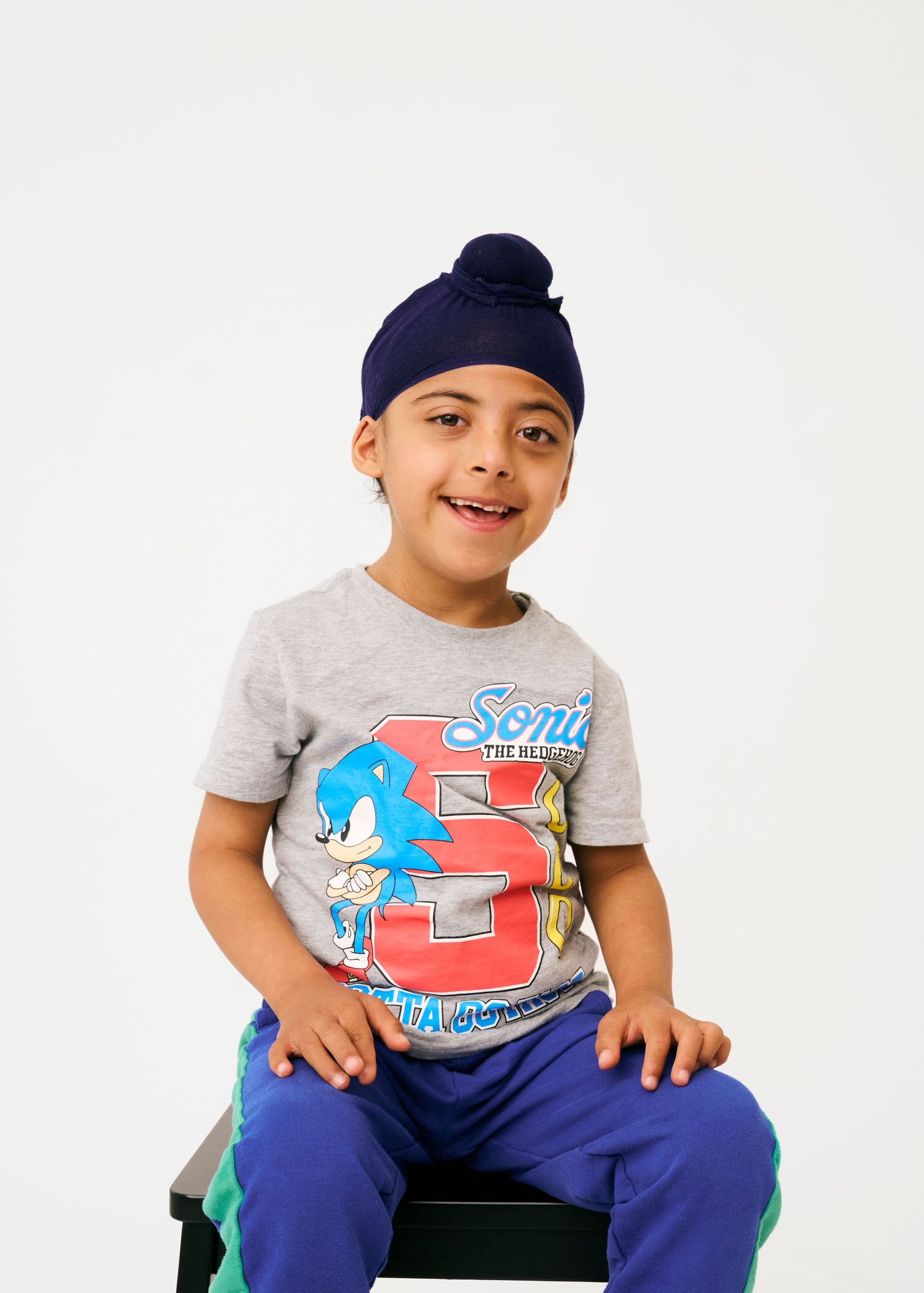 A series of poses in a grey Sonic t-shirt and blue pants against a white background.