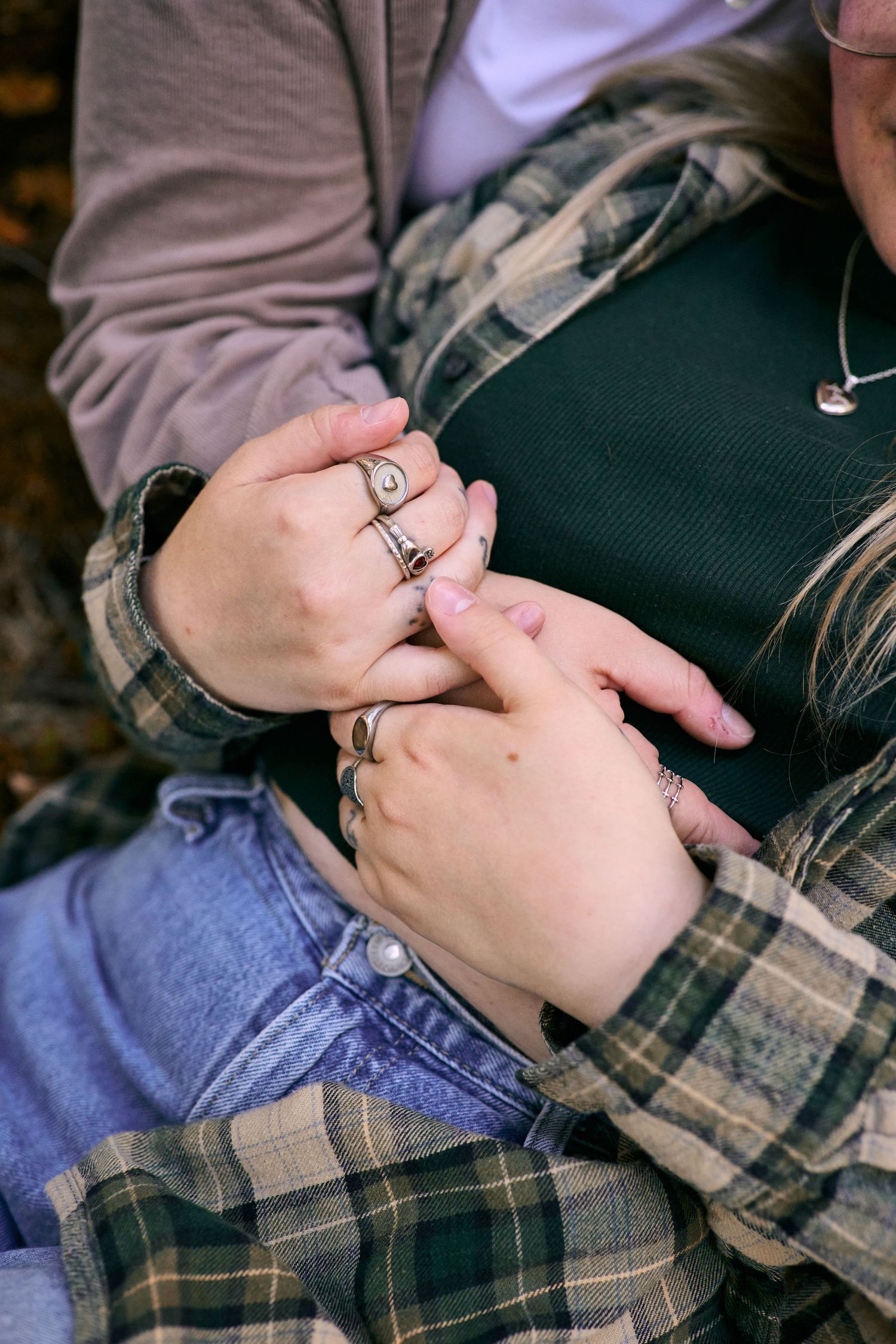 Close-up sequence of hands wearing rings resting on plaid fabric and denim.