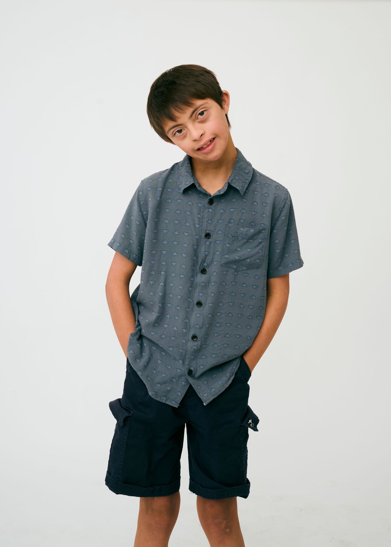 Multiple views of a person wearing a grey button-up shirt and black shorts in a photo studio.