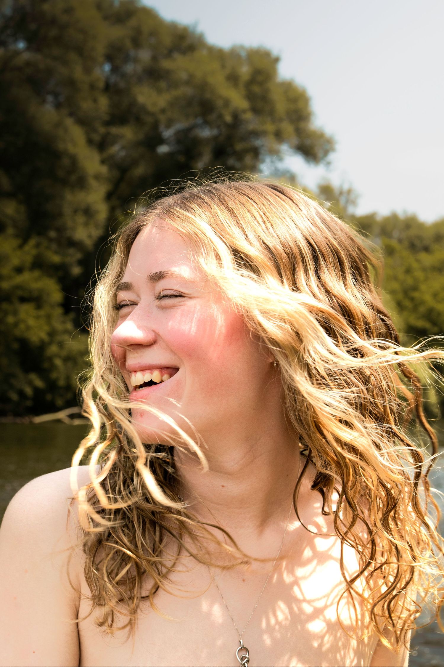 Sunlit photo showing wavy blonde hair blowing in the wind.